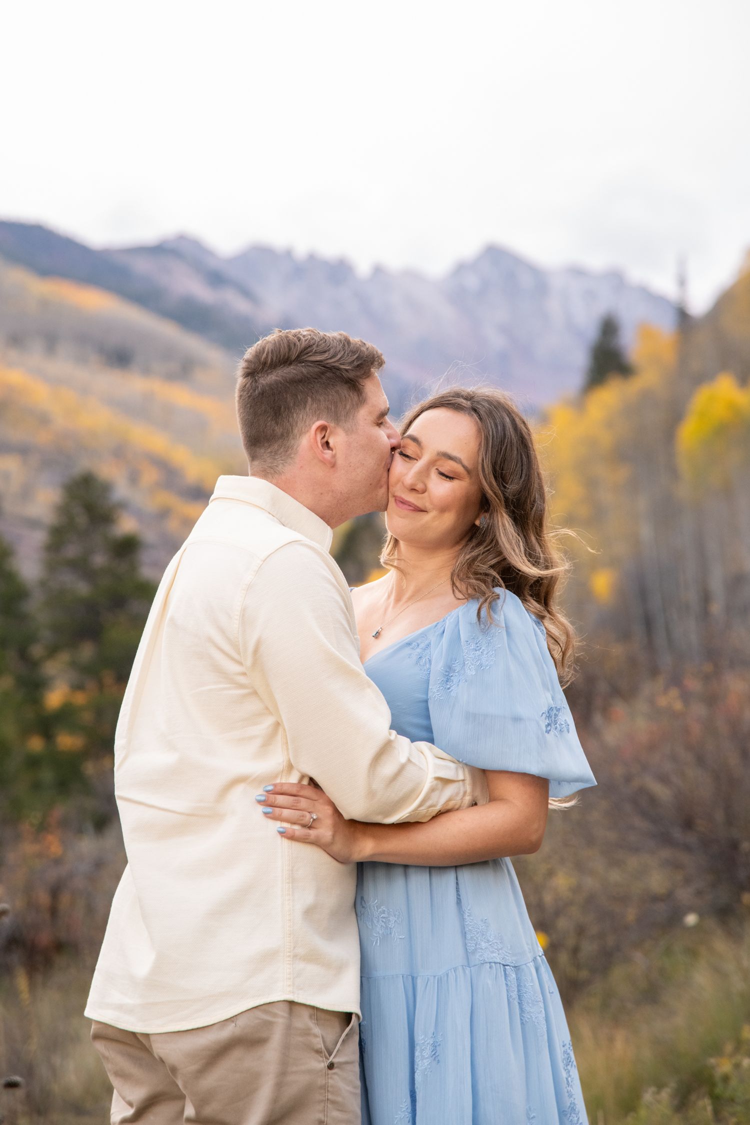 Vail engagement photos with a couple who shares a romantic kisses against a backdrop of autumn mountains and fall foliage.