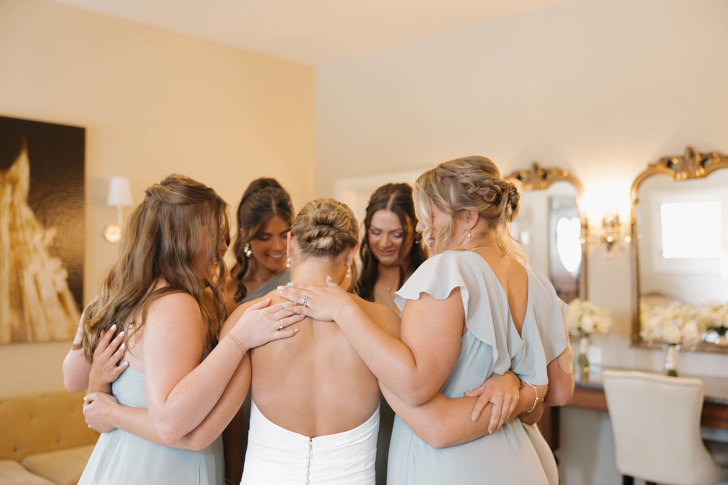 A series of wedding party photos showing bridesmaids in light blue dresses getting ready in a bright indoor venue.