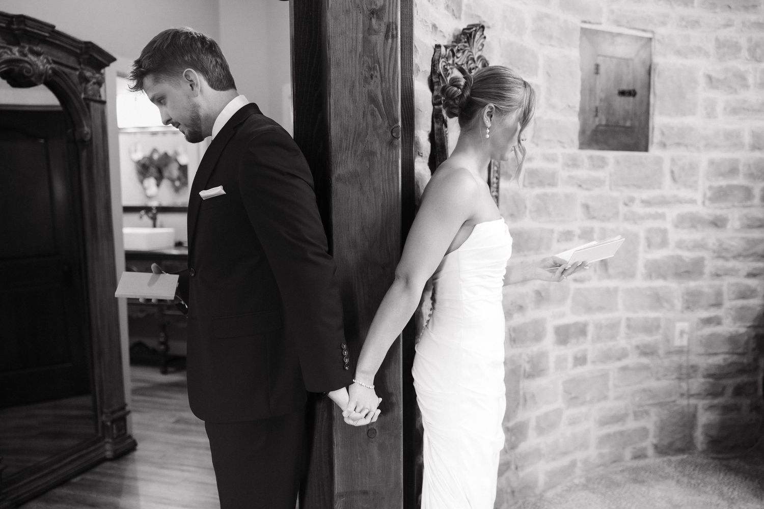 Black and white photos showing intimate first look moments between newlyweds against a brick wall backdrop.