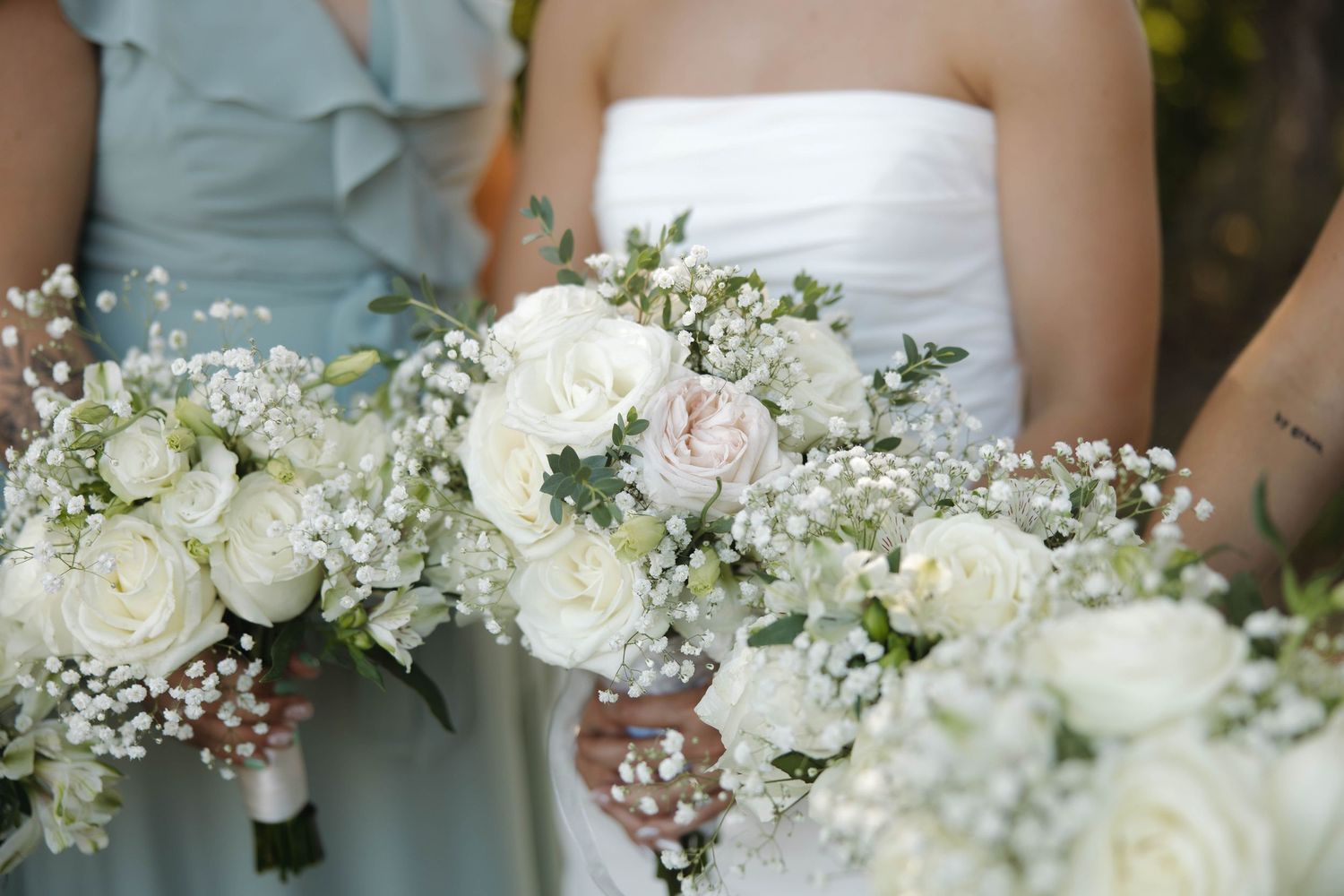 Delicate white and blush floral bouquets with baby's breath arranged in a row.