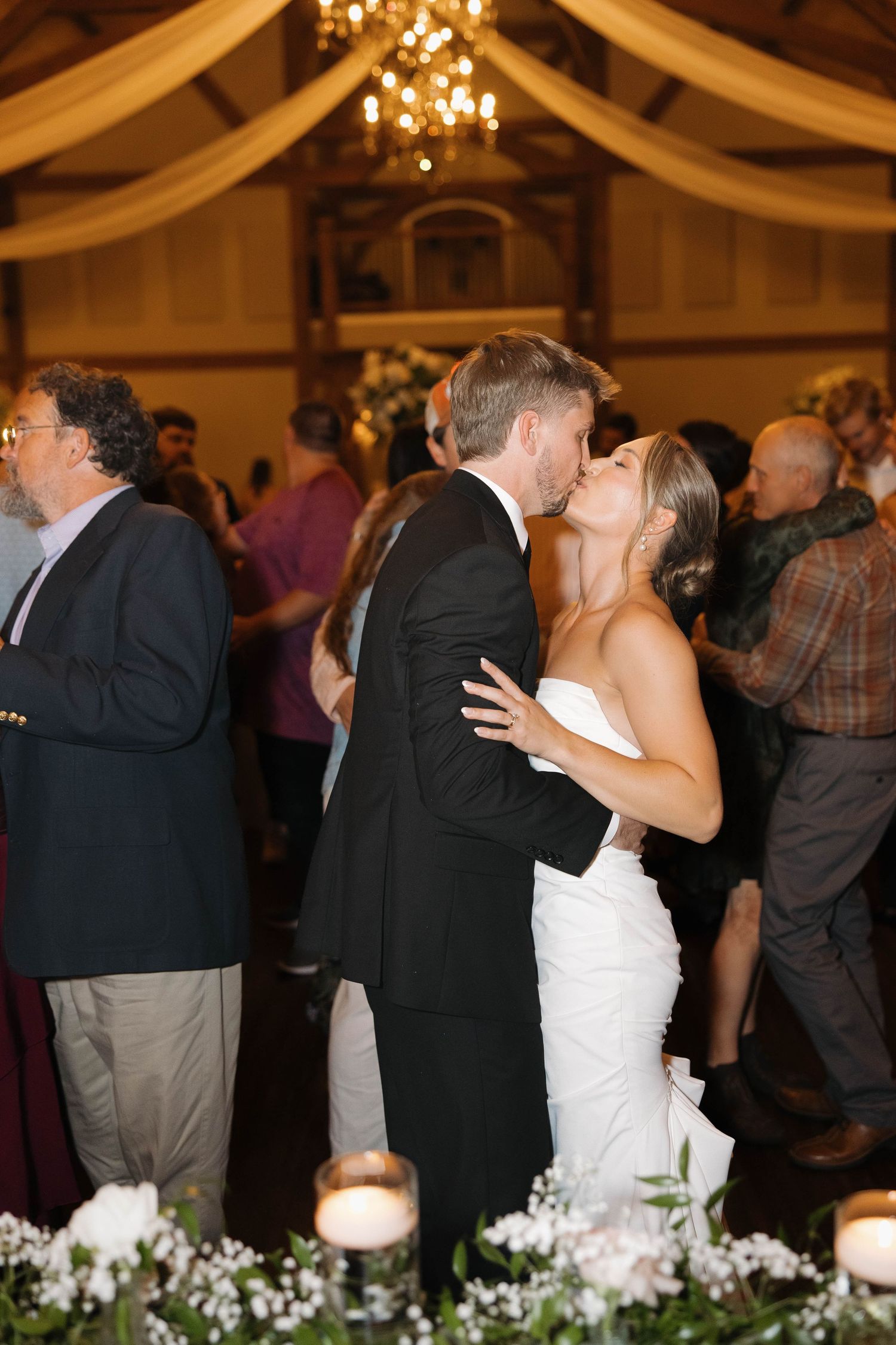 Wedding reception dance sequence showing a couple's first dance under elegant chandeliers and draping.