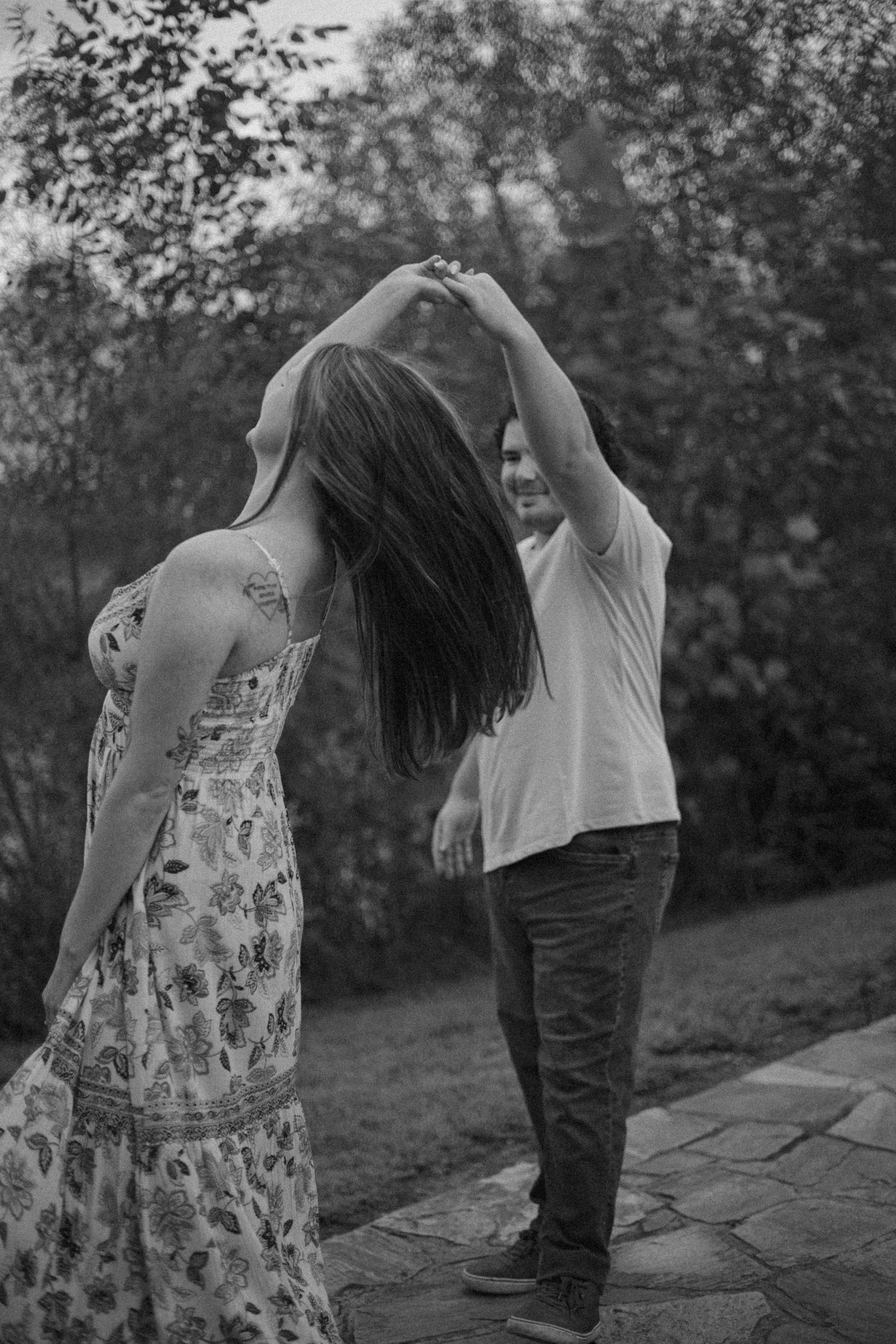 Black and white photos of a couple dancing together outdoors.