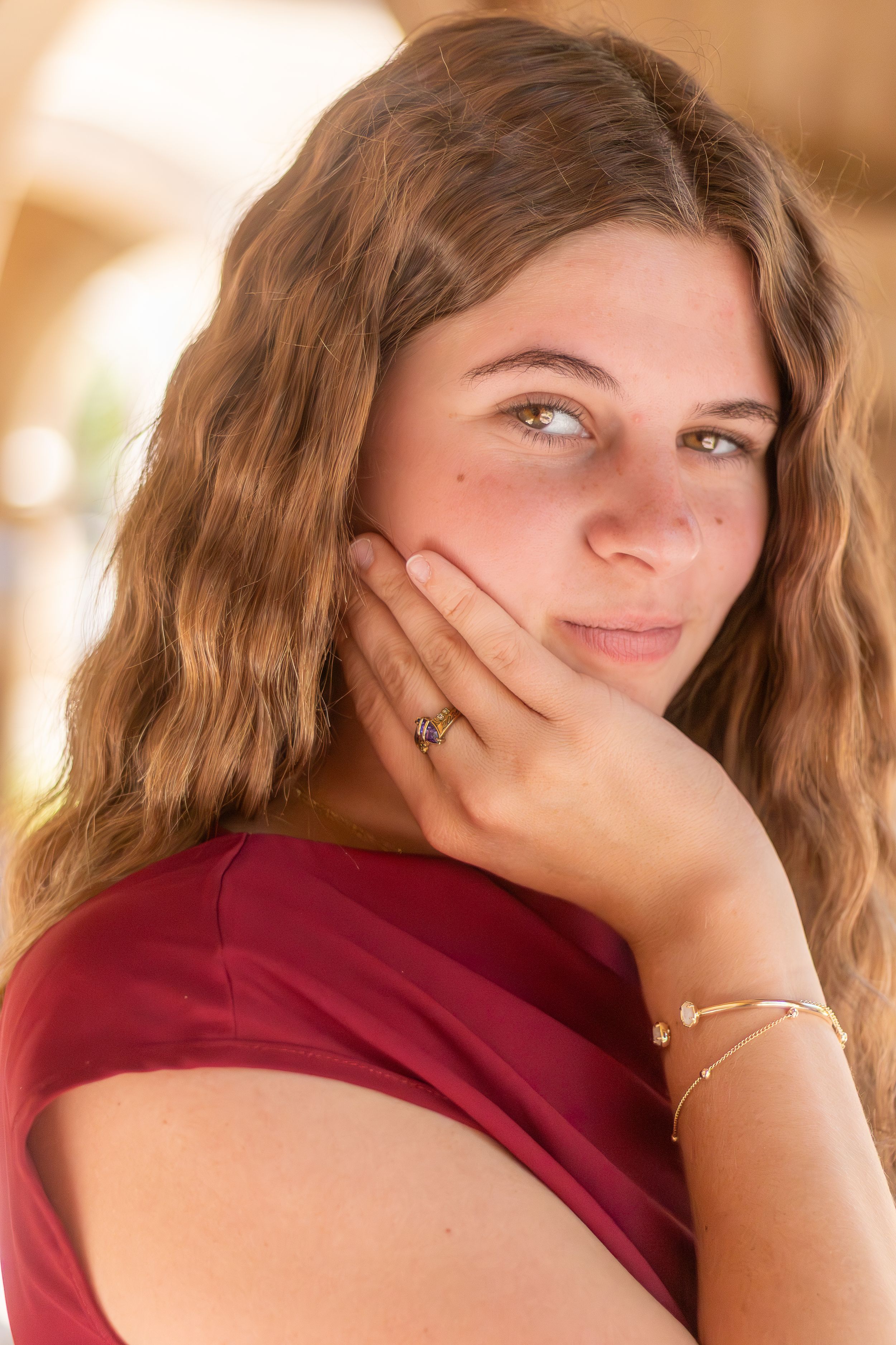 A person in a burgundy shirt poses playfully in a series of headshots with varying expressions.