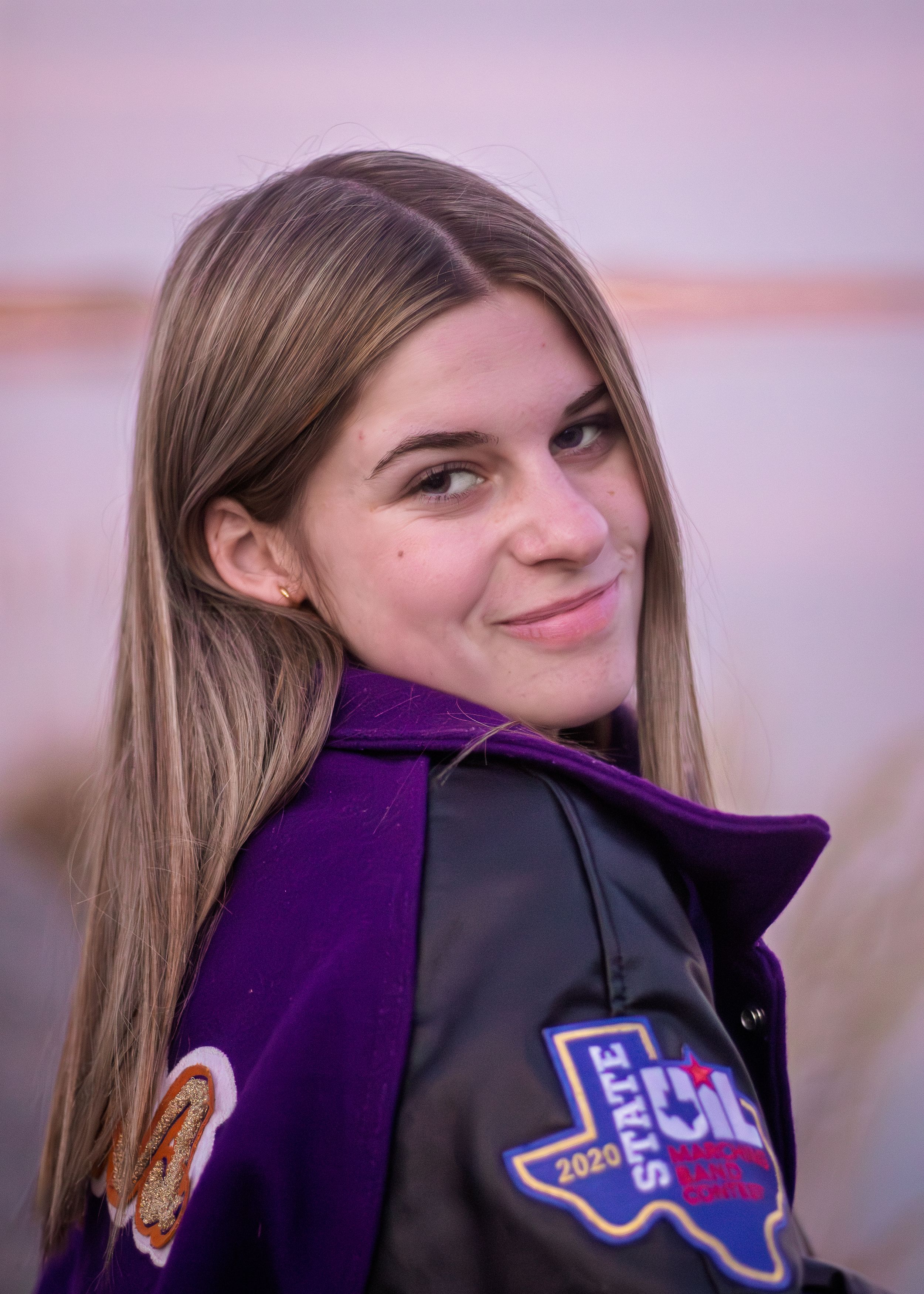 Young woman in a purple and black varsity jacket with a 2020 State Girls championship patch.