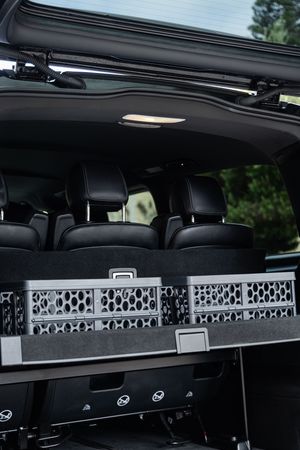 Interior view of luxury van showing black leather seats and decorative storage compartments.