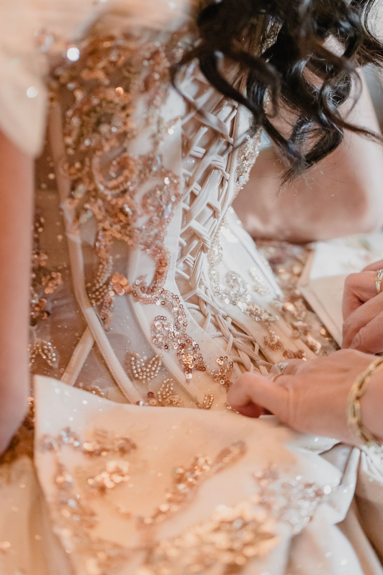 Close-up detail of an ornate white wedding dress with delicate beading and embellishments.