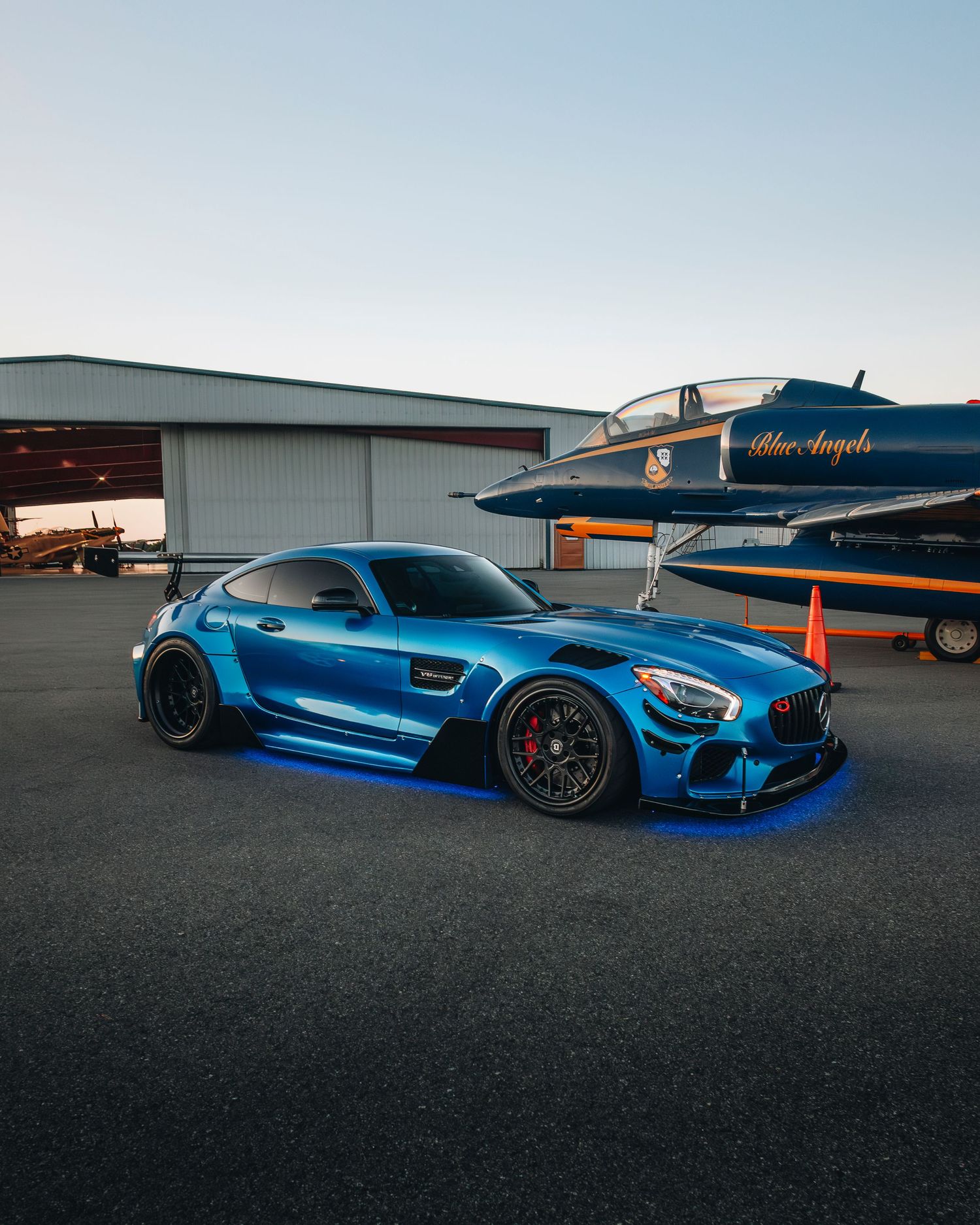 Sleek blue Lamborghini parked outdoors under clear skies