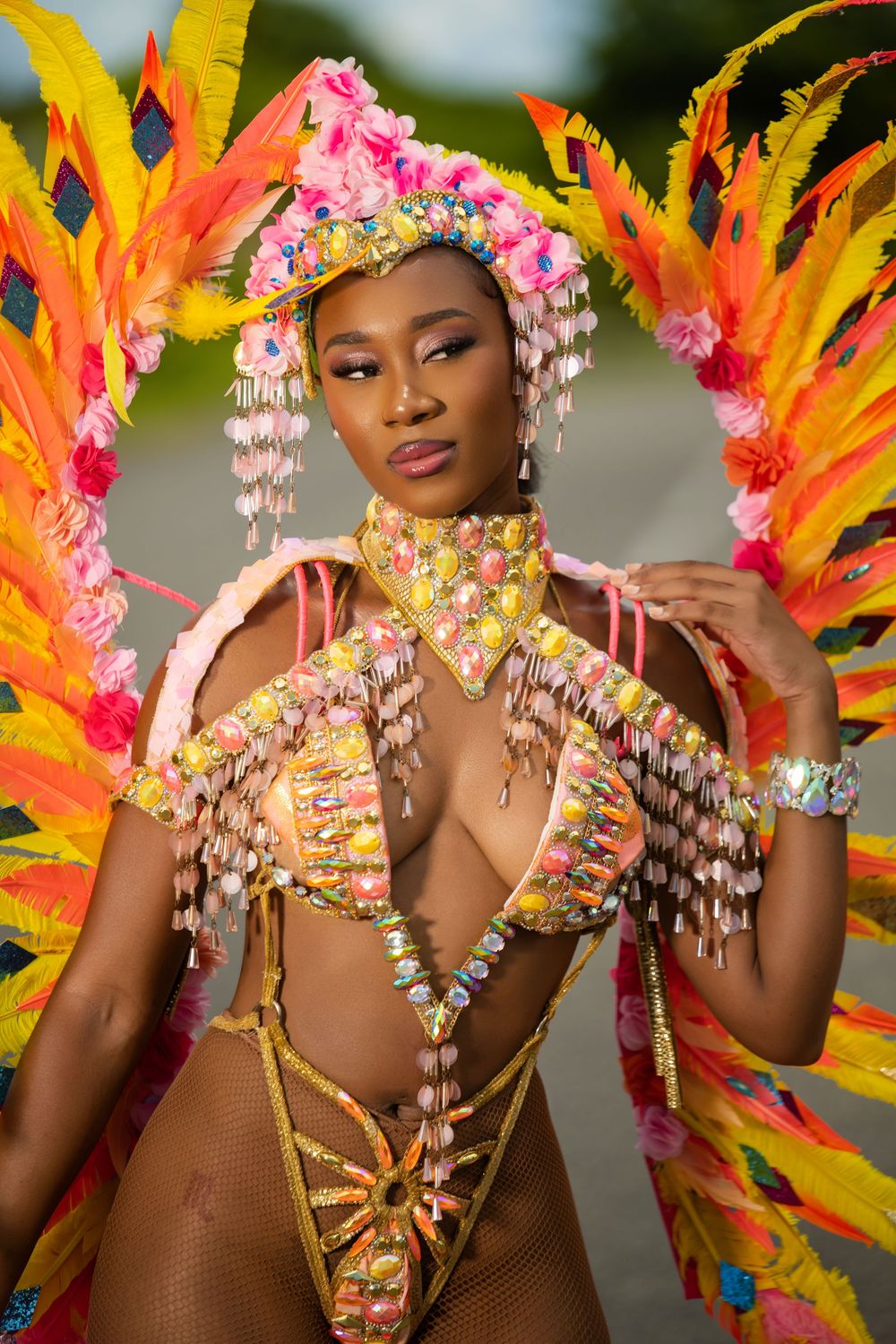 Carnival costume with orange feathers and pink floral headdress showcasing intricate details.