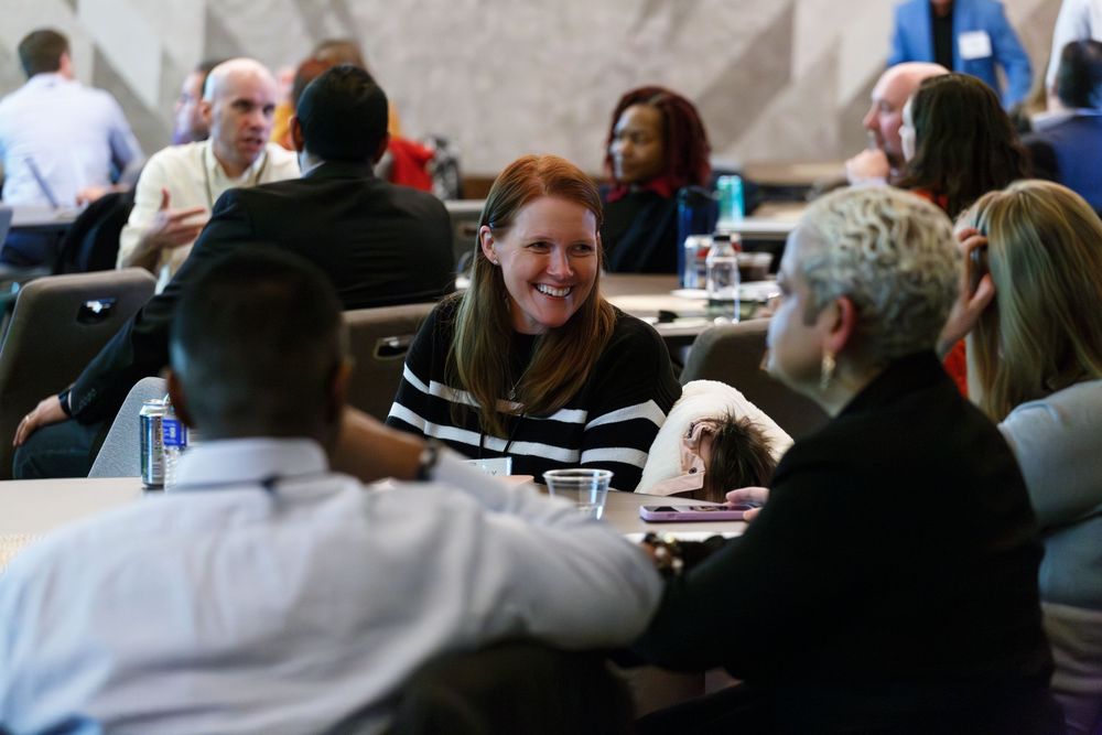 Diverse group of professionals engage in roundtable discussion at business conference.