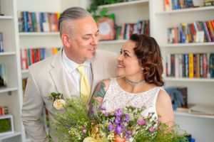 A couple in wedding attire smile at each other in a library Quad Cities Wedding Photography