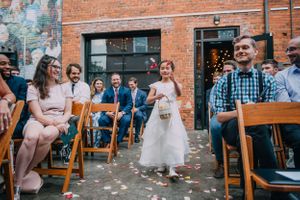 Flower girl walks down the aisle at the Cookery in Durham NC