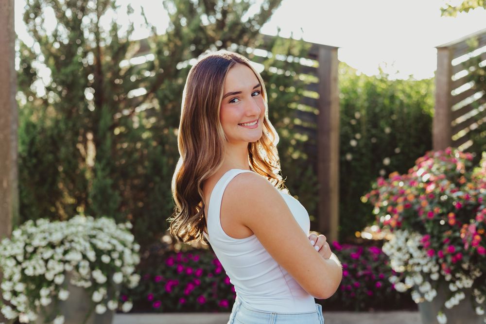Outdoor lifestyle portraits in a garden setting with blooming flowers and wooden pergola.