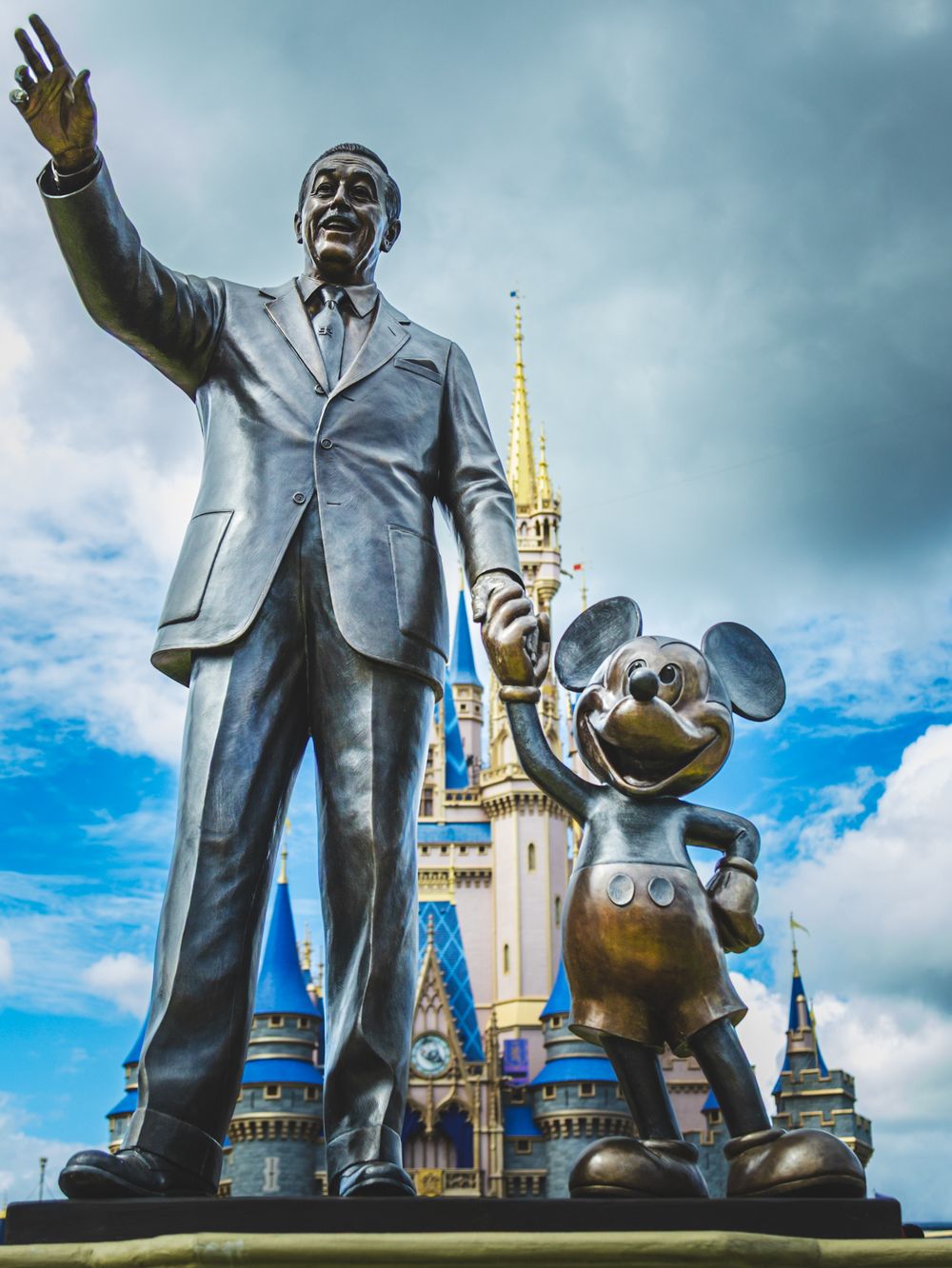 Low-angle view of iconic Partners Statue with Cinderella Castle in the background at Magic Kingdom.