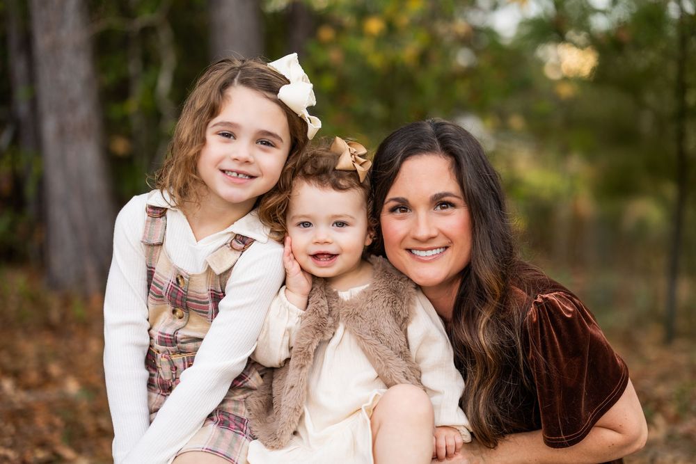 Casual family portrait session on wooden stools among fall foliage.