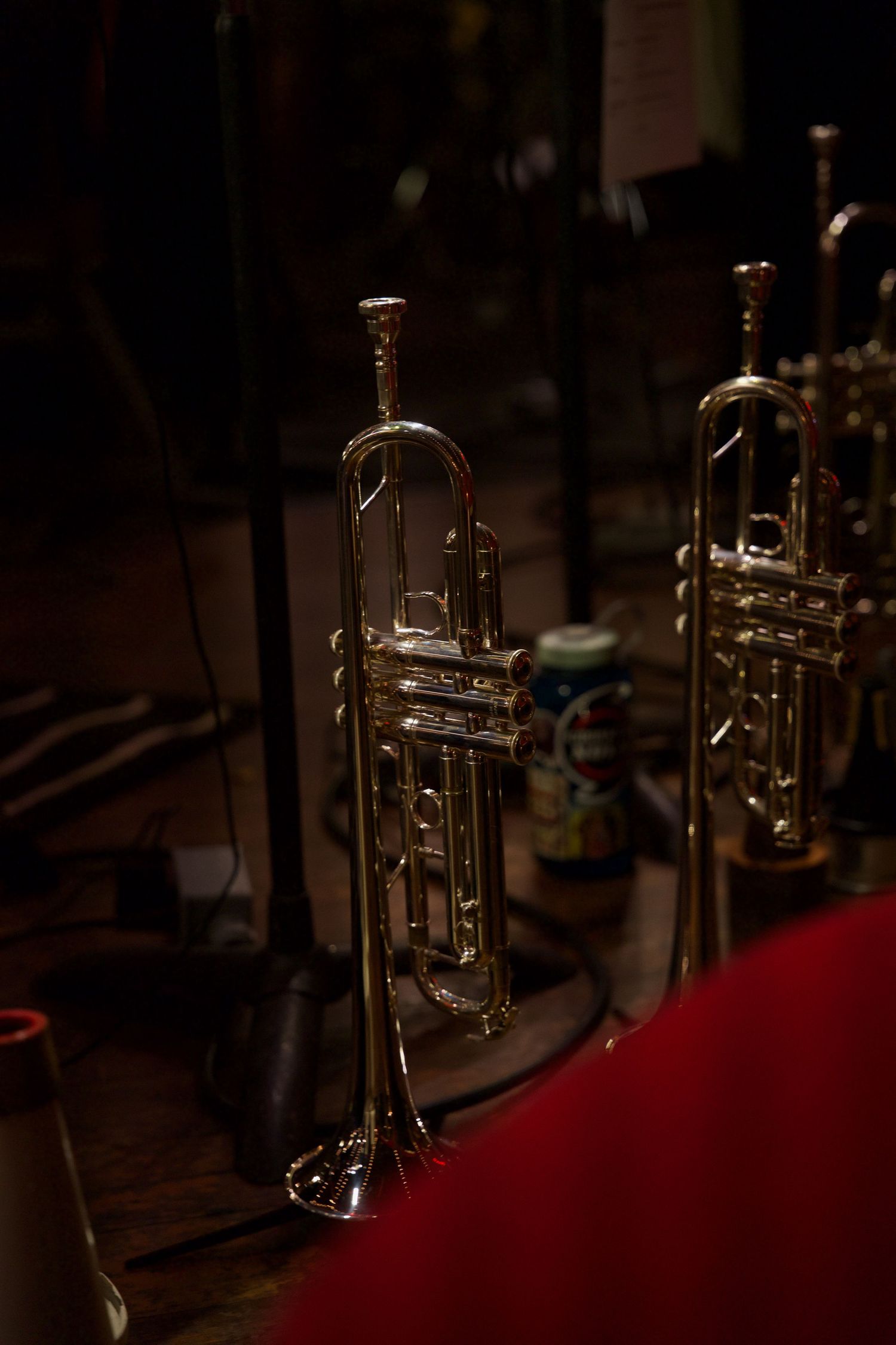 Brass trumpets on display in moody, dramatic lighting at a musical event.
