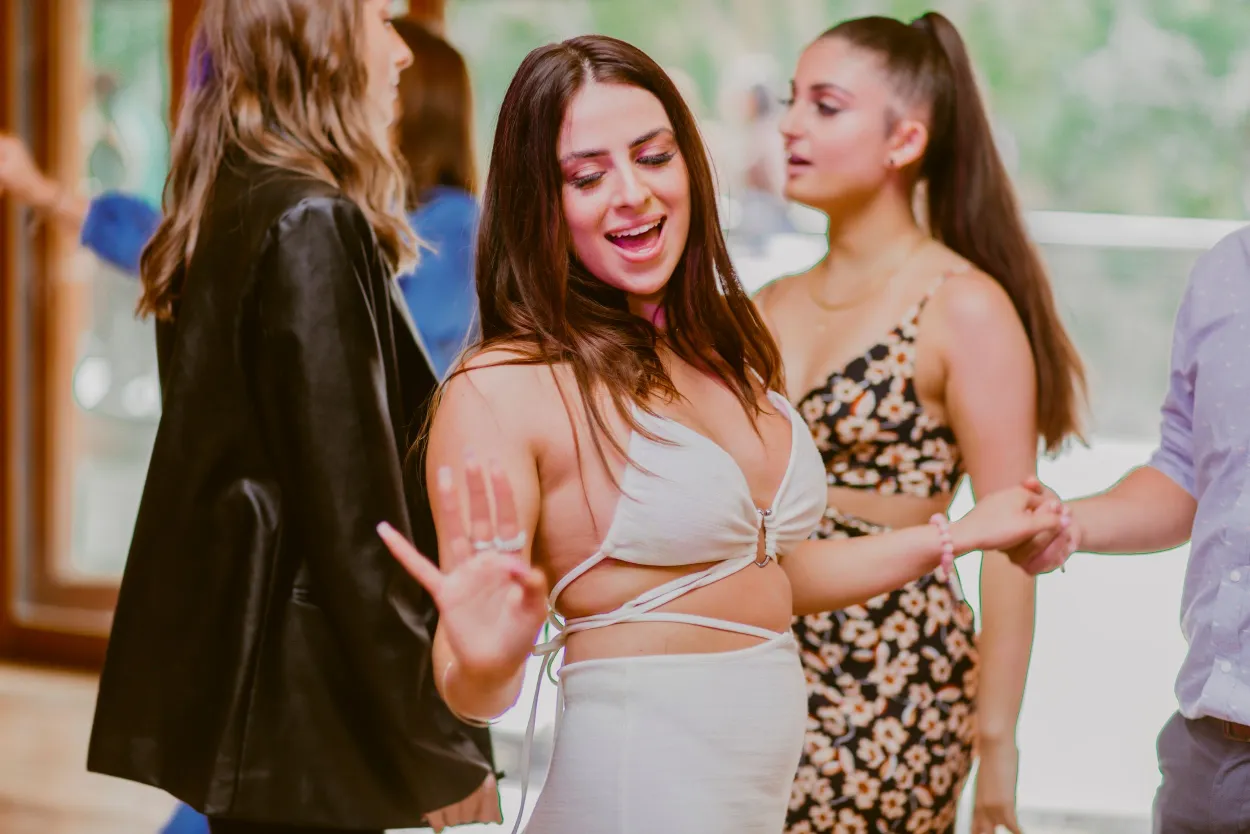 Group of friends dancing and celebrating at an indoor social gathering.