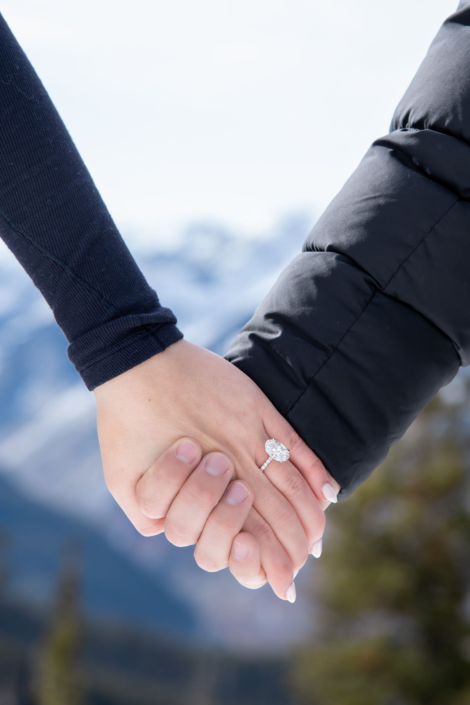 Detail photo of engagement ring with mountain peaks in the background after a surprise proposal at The Aspen Wedding Deck.