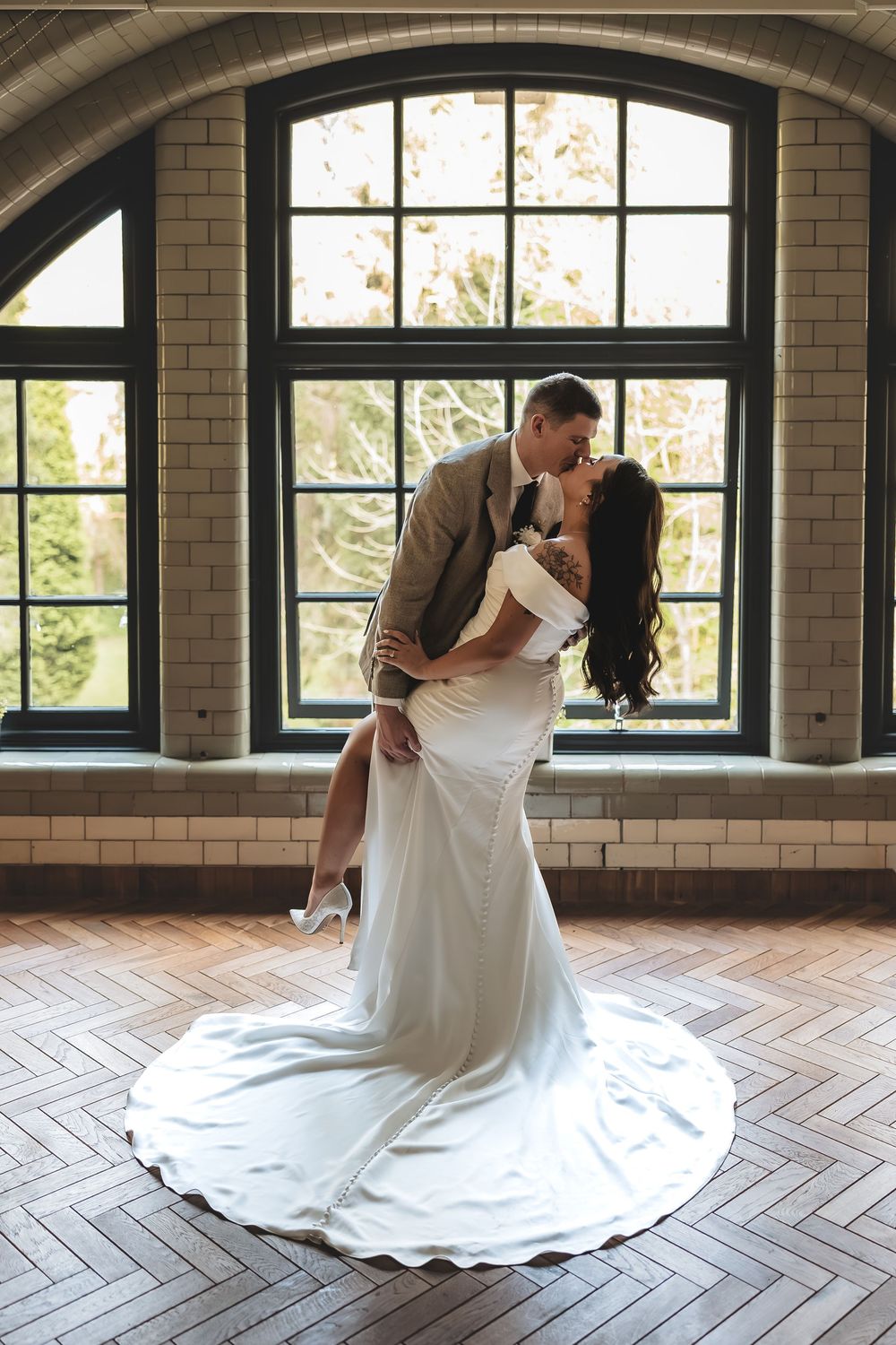 A relaxed guided wedding portrait of bride and groom during a shared kiss in their Nottinghamshire wedding venue.
