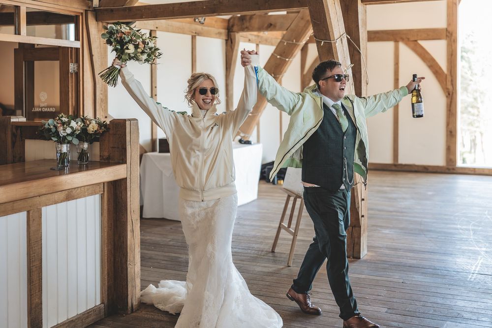 Fun natural wedding moment captured unobtrusively as bride and groom enter their wedding reception.