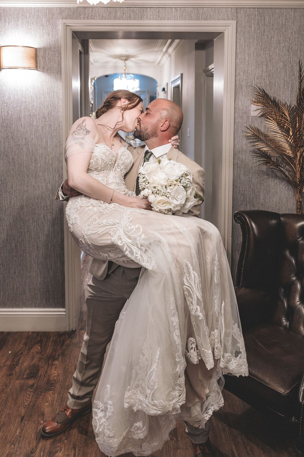 A fun unobtrusive photo of a bride and groom sharing a  kiss.