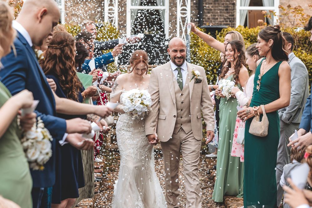 Emotional and fun confetti moment as bride and groom share their day with family.