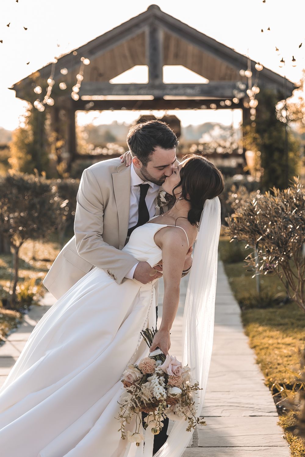 A documentary photo captured beautifully of newly-weds sharing an intimate kiss at their wedding venue.