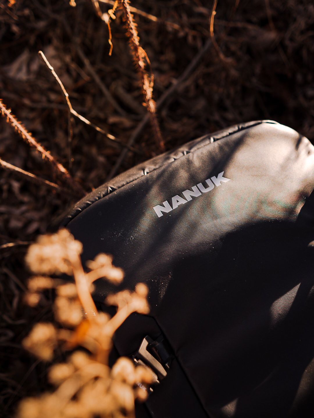 Close-up detail of black outdoor gear with Nanuk branding in natural lighting.