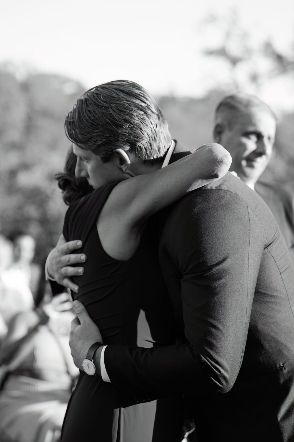 Emotional embrace captured in black and white during wedding celebration.