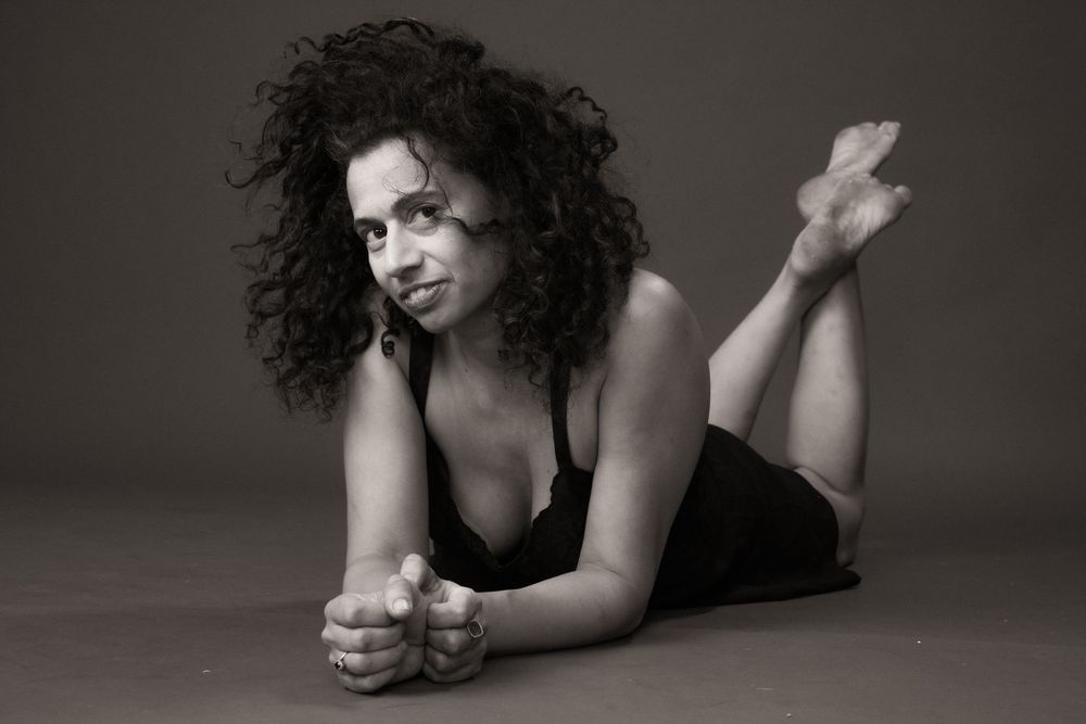 A black and white artistic portrait series showing a figure in various reclining poses against a dark background.