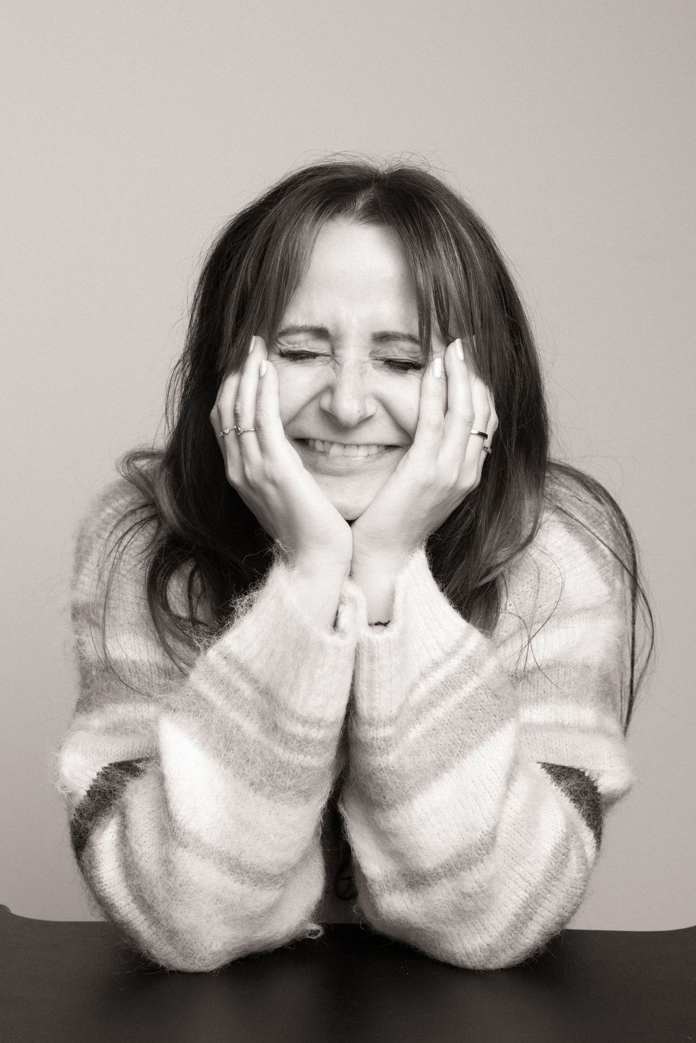 Black and white photo series showing someone covering their face with hands in different playful expressions.