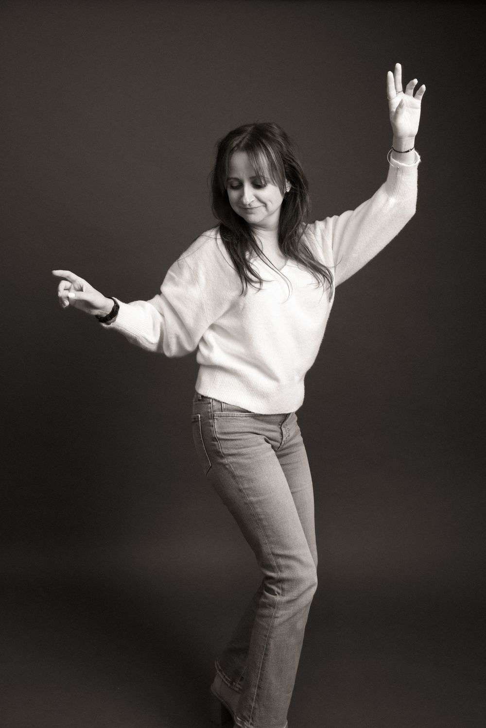 A sequence of dance poses showing energetic movement against a dark background in black and white photography.