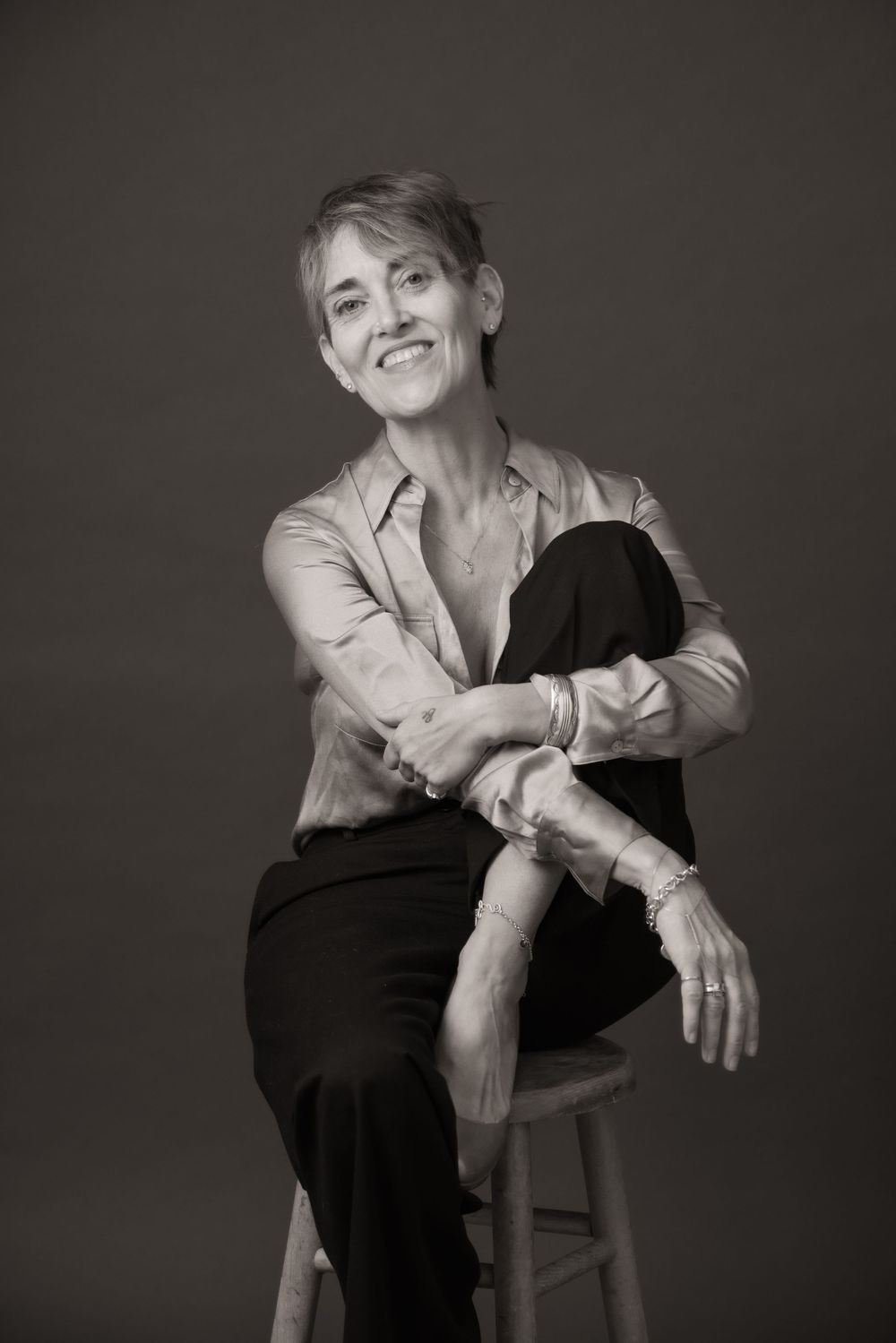 Black and white portrait series showing a person in casual attire posing expressively against a dark background.