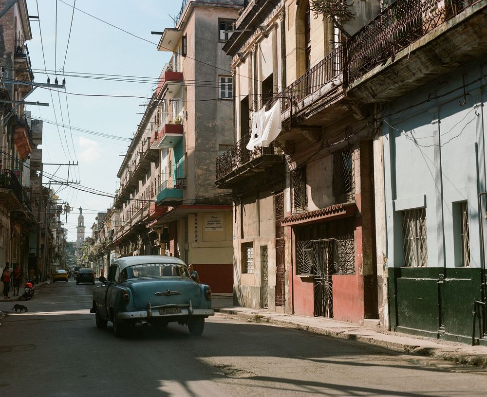 Empty urban street with historic buildings and power lines in Cuba.