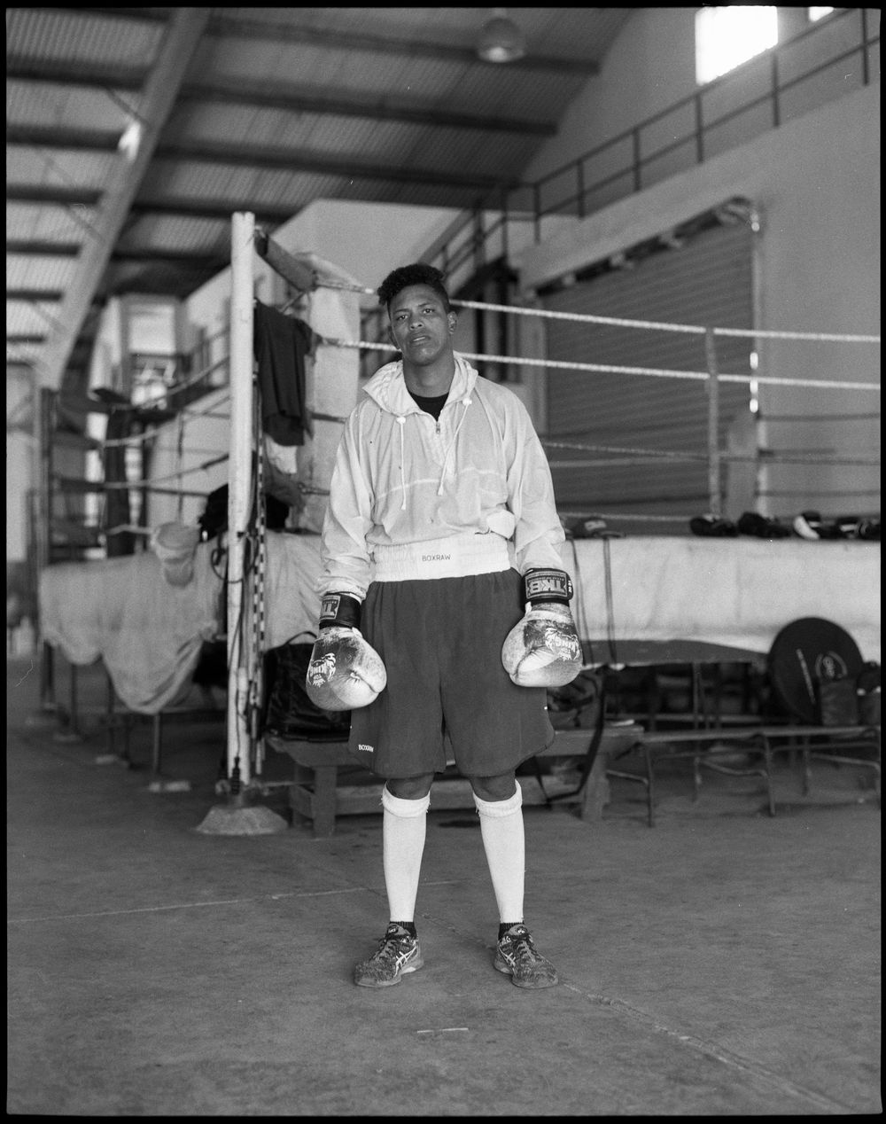 Black and white photographs showing someone stretching and warming up in a gym setting.