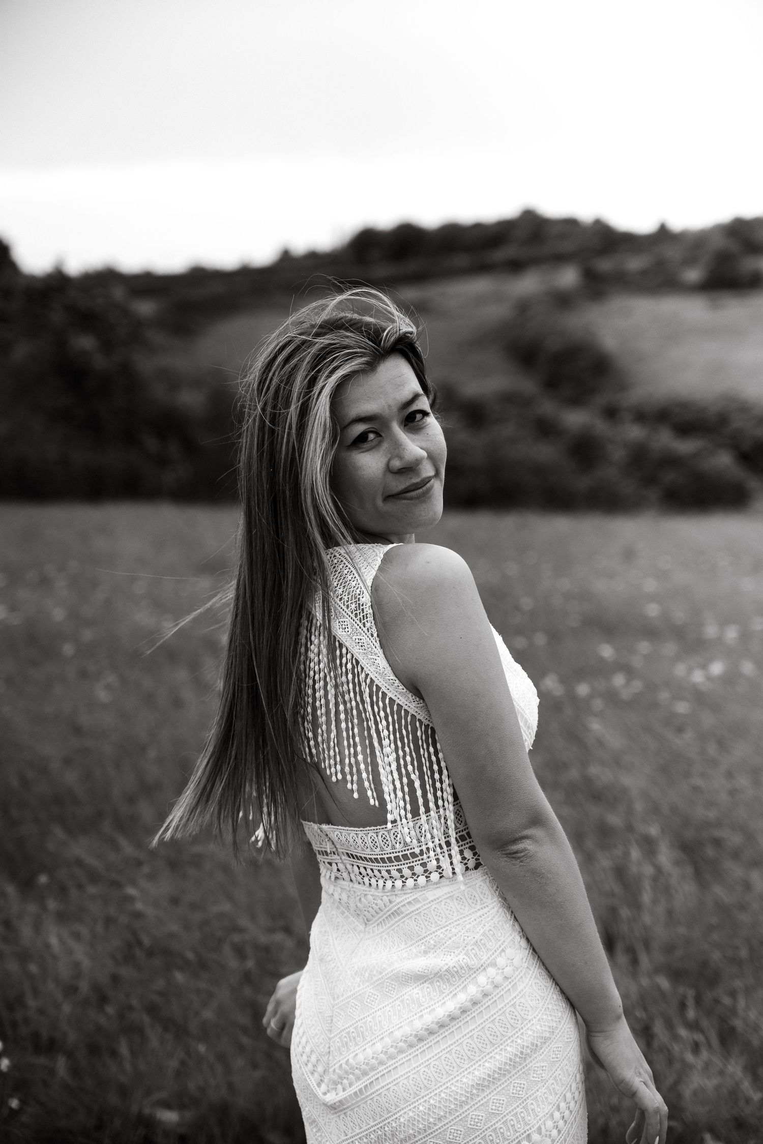 Black and white portraits of a bride in a lace dress against a rural landscape.