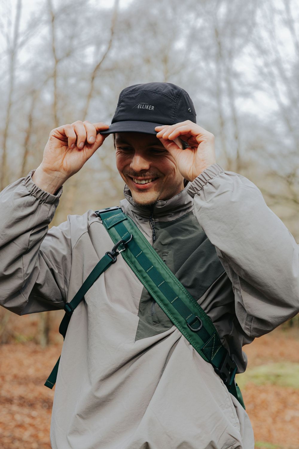 A person in a gray hoodie and black cap playfully adjusts their hat in a series of four sequential photos.