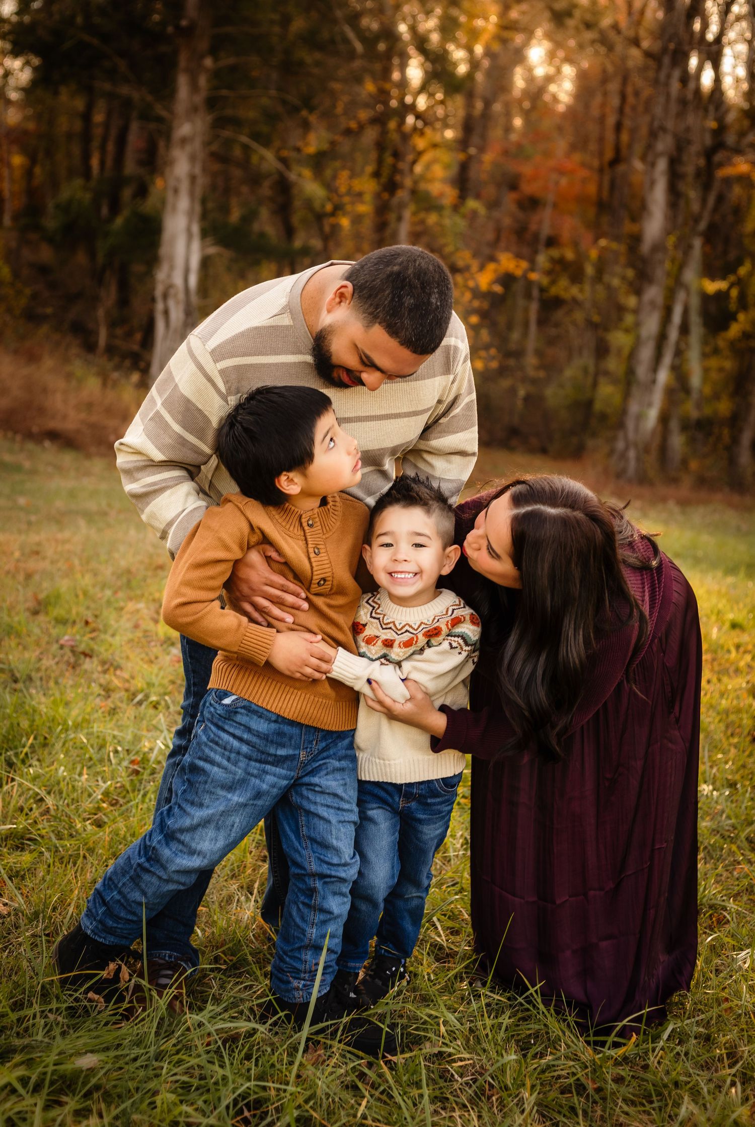 Adorable family of four enjoys a candid moment of connection during their fall session, captured by Charlottesville newborn photographer.
