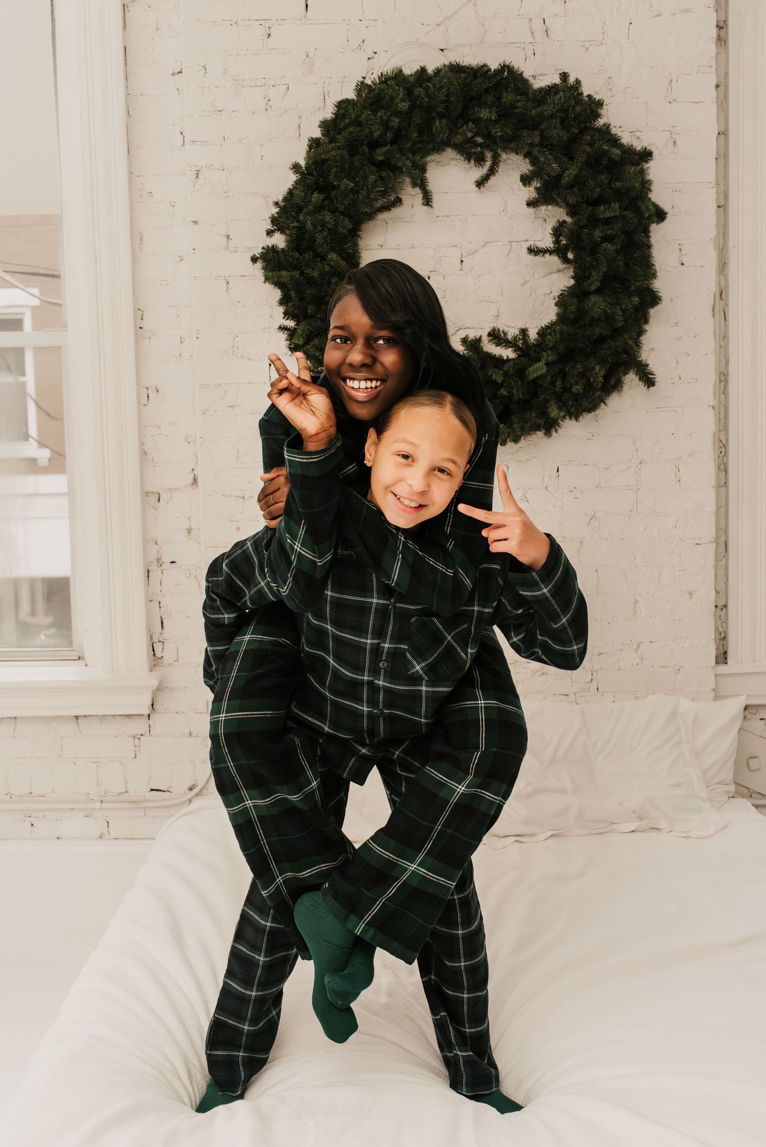 sisters hug together in their matching pajamas during their winter mini session