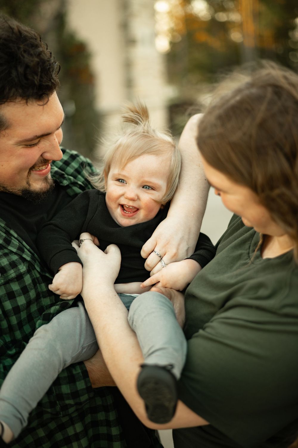 Playful family moment captured in natural light with laughter and joy.