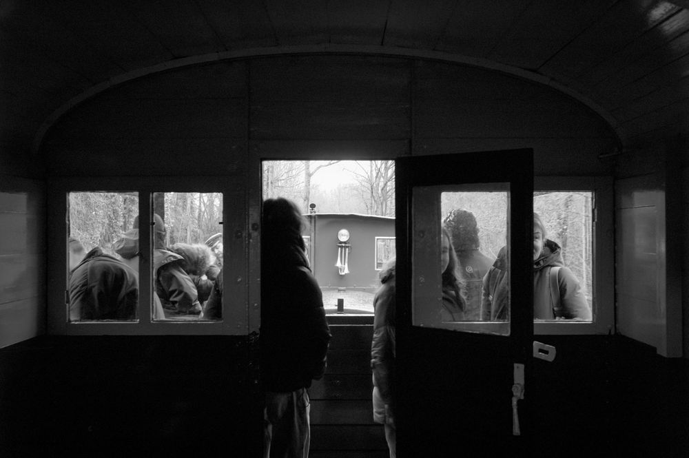 Artistic black and white photo of silhouettes in a window frame creating a dramatic urban composition.