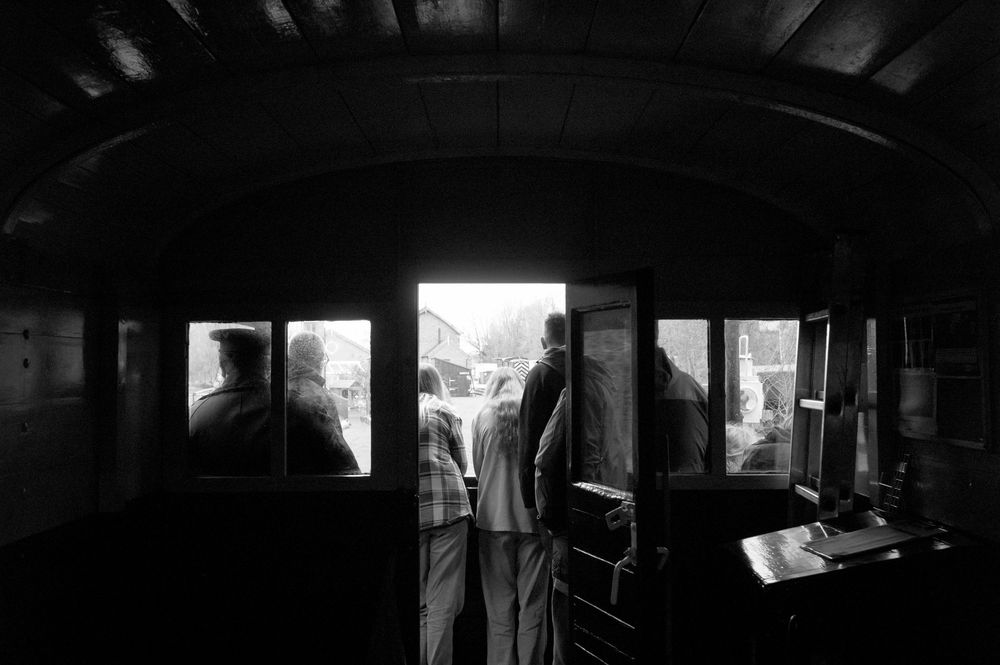 Dark and moody interior shots of a dimly lit room with windows and furniture creating dramatic shadows and silhouettes.