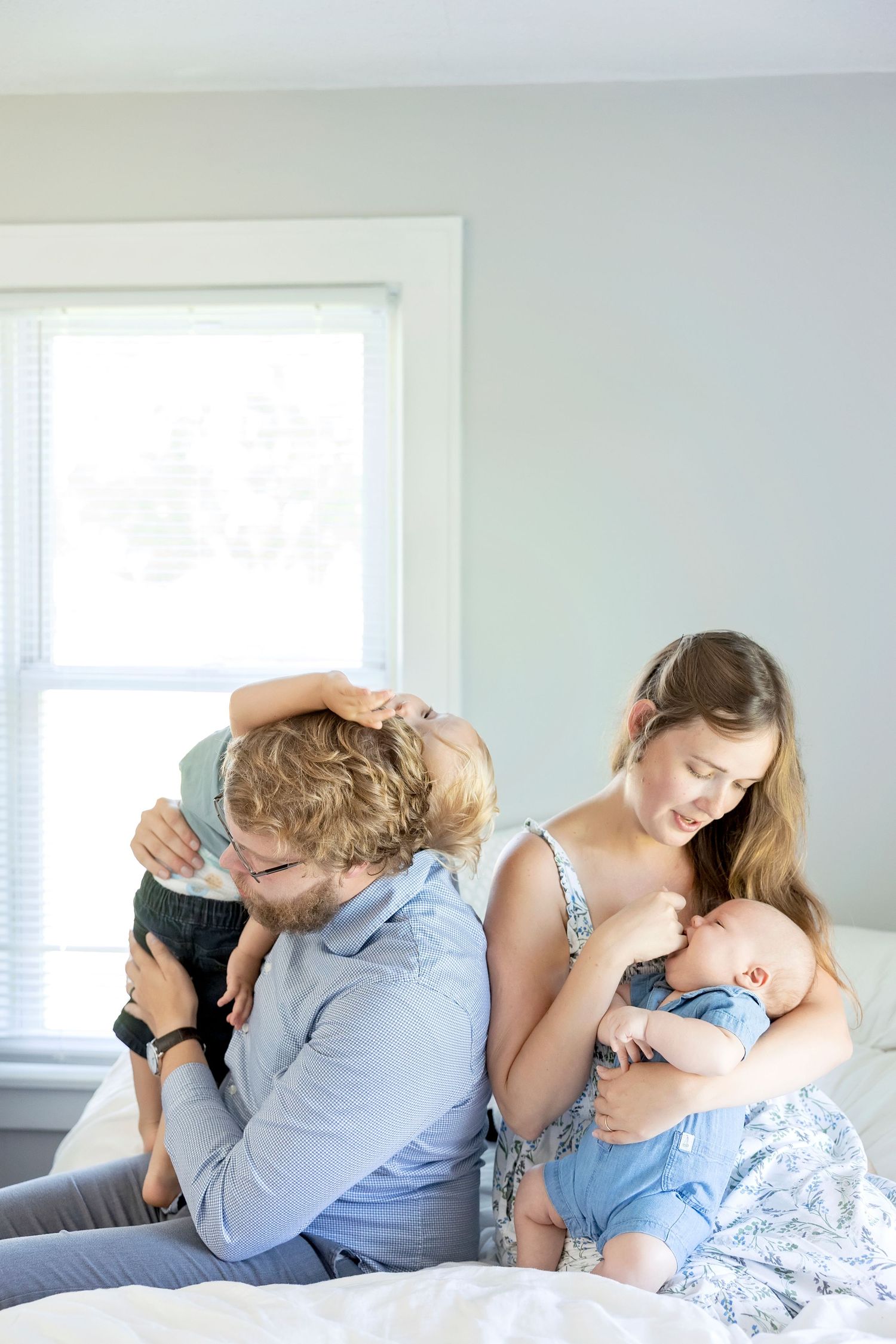 A sequence of intimate family moments showing tender embraces and cuddles on a light gray couch in a bright room.