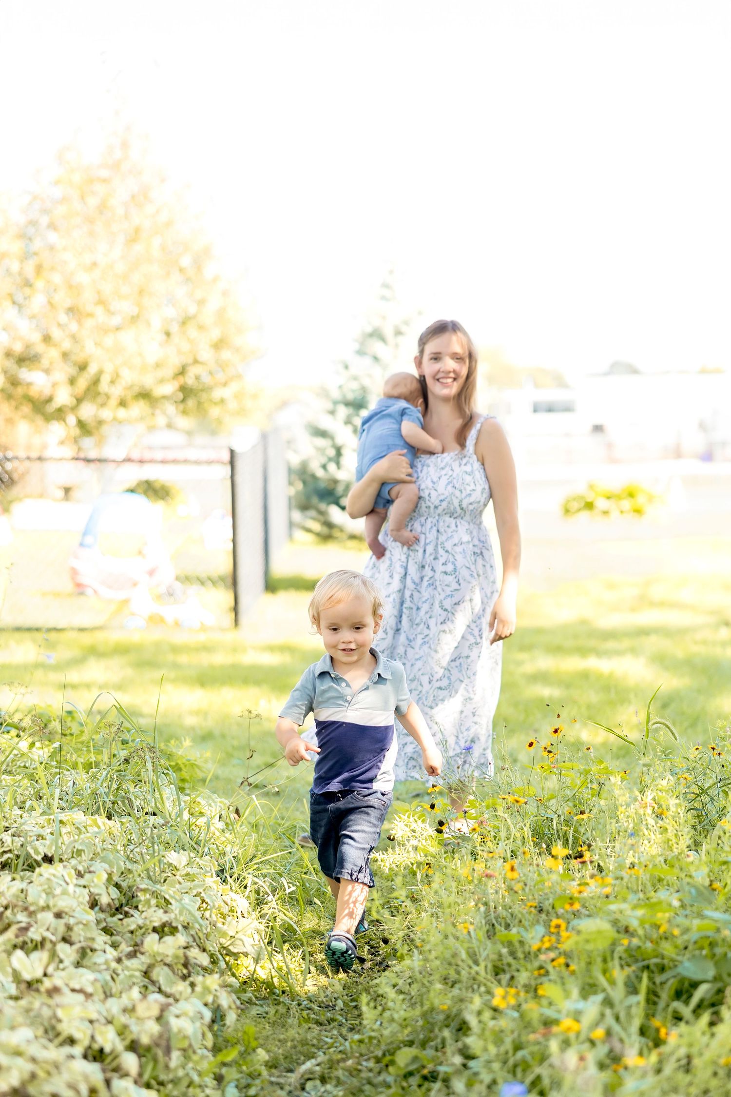 A light summer scene in a wildflower meadow with figures enjoying a sunny afternoon walk together.