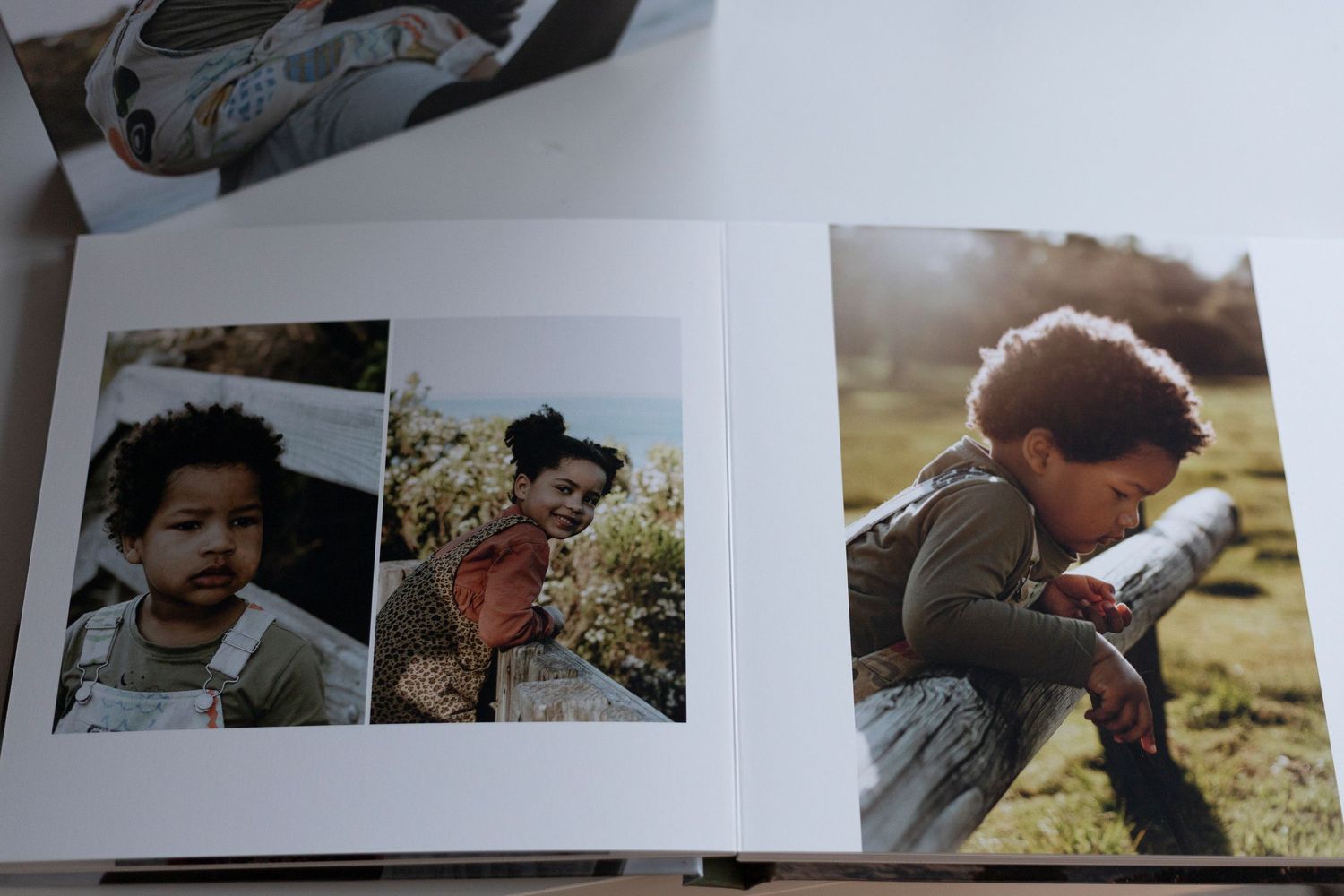 An open photo album displaying candid outdoor snapshots on white pages.