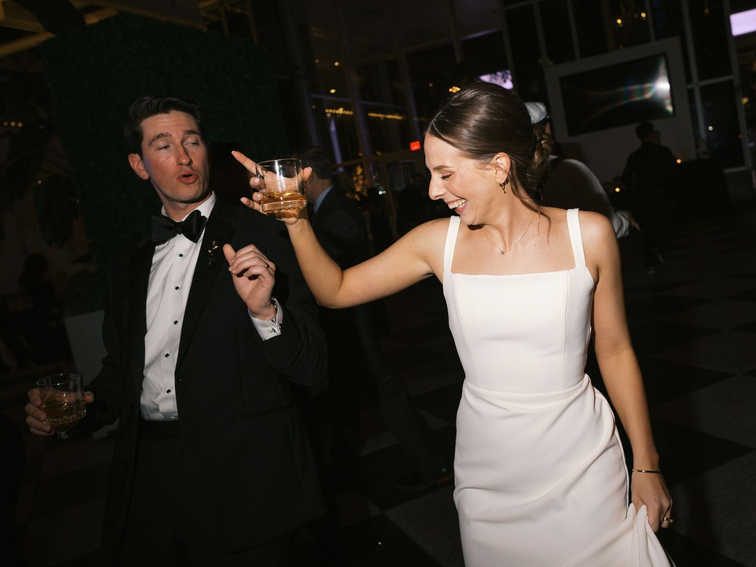 A group of elegantly dressed people dancing and socializing at a formal evening event.