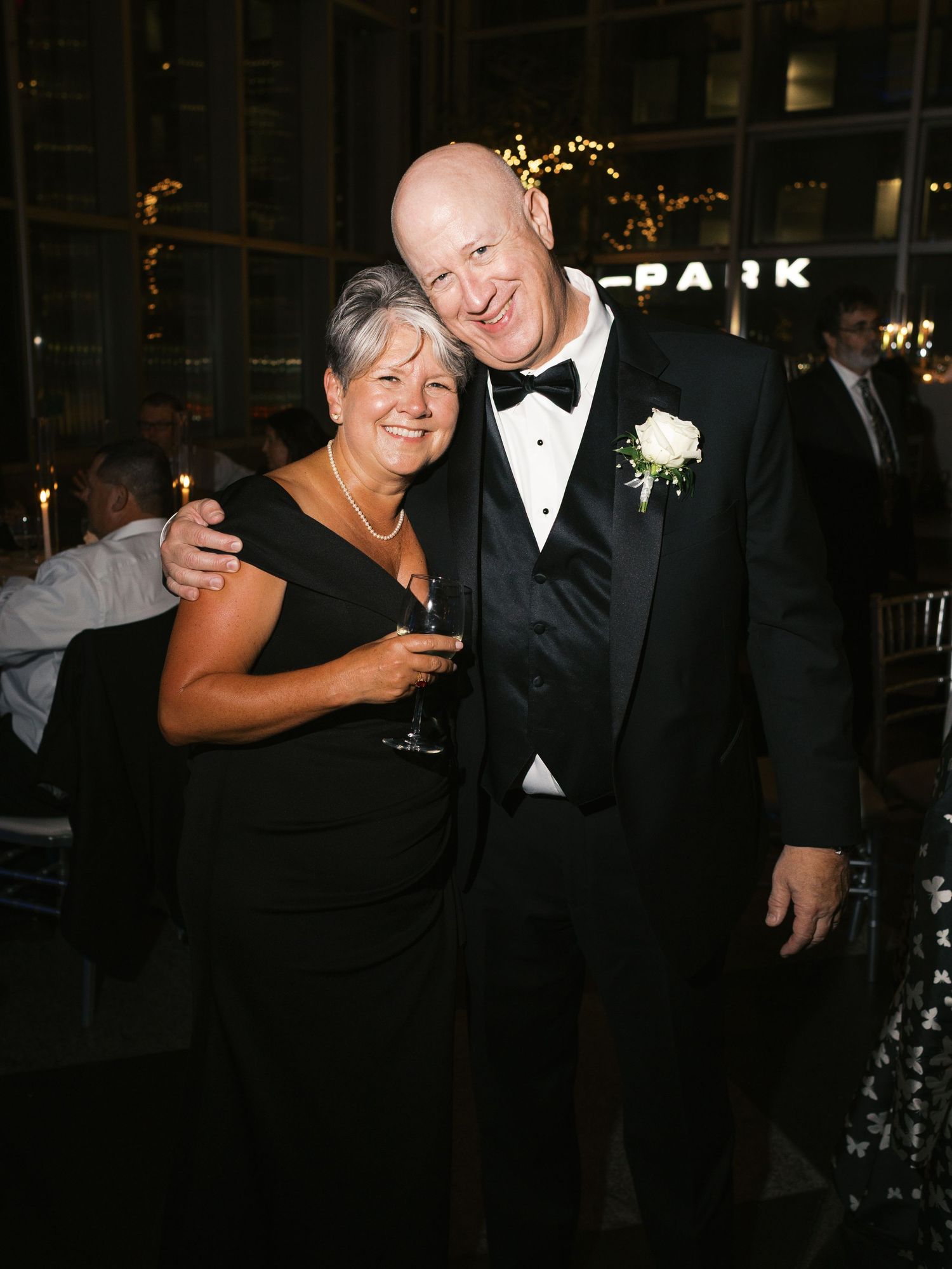 Wedding guests celebrate and smile together during an evening reception.