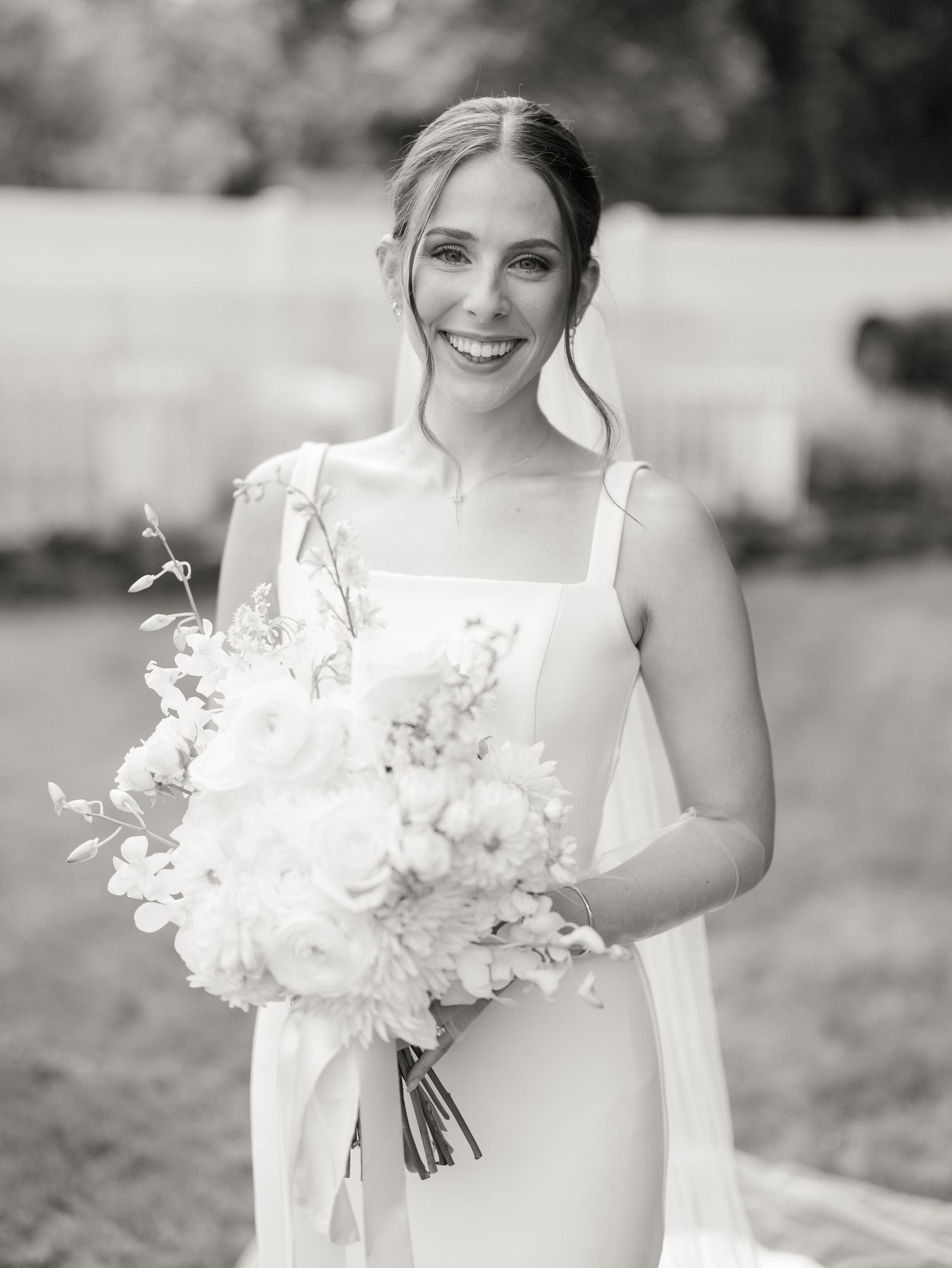 Black and white portrait series showing a bride in a white dress holding an elegant bouquet of flowers.