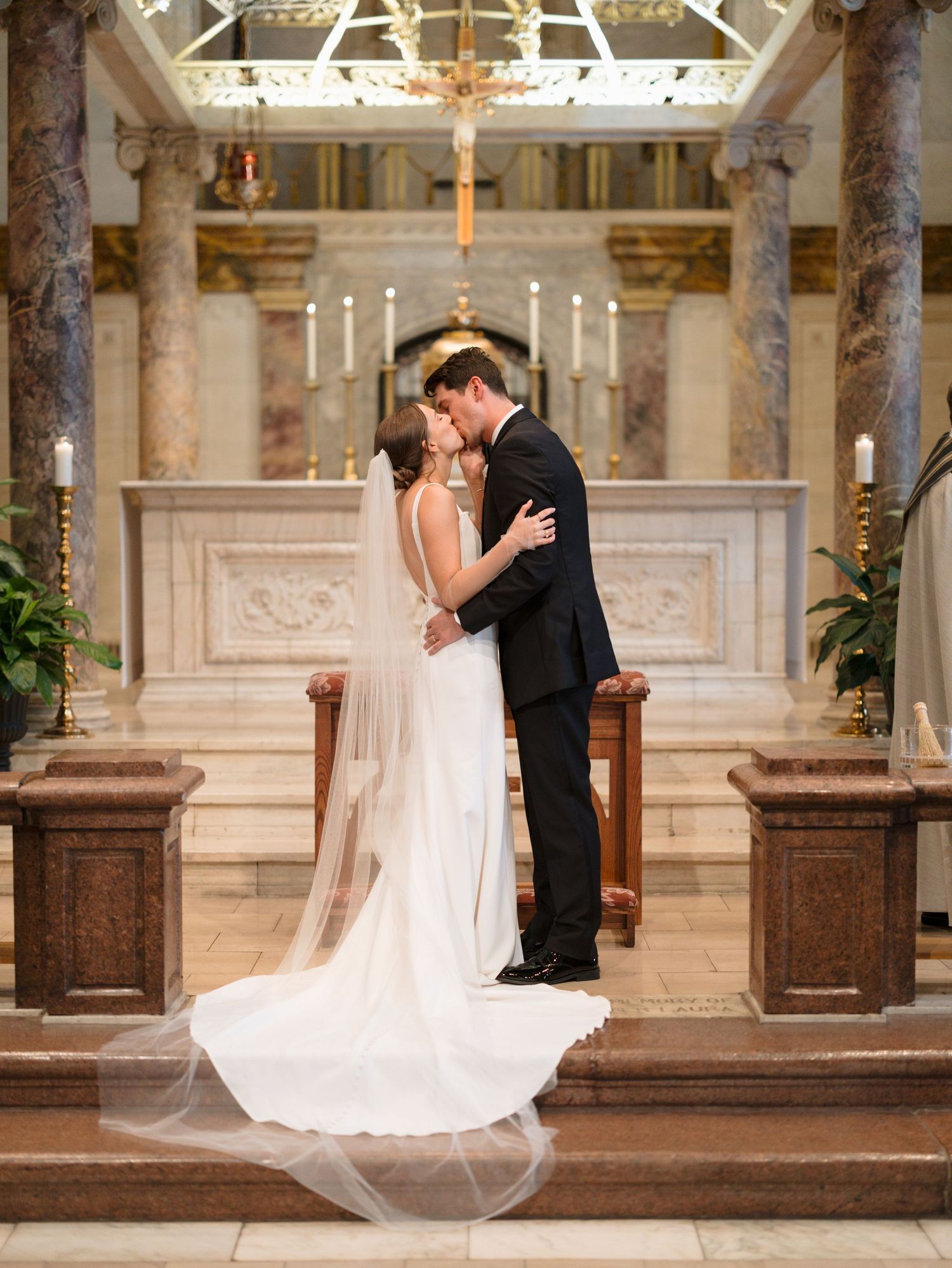 Romantic wedding moment at the altar of a beautiful marble church with classical architecture.