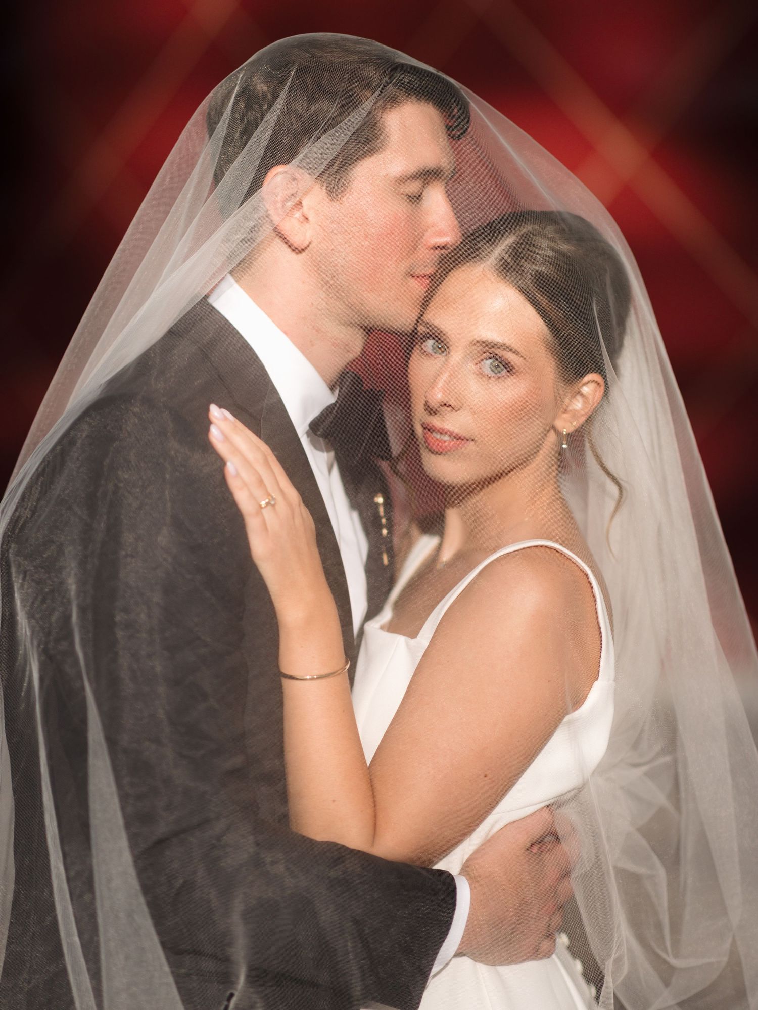 Intimate wedding portraits of couple in dramatic lighting with flowing white veil.