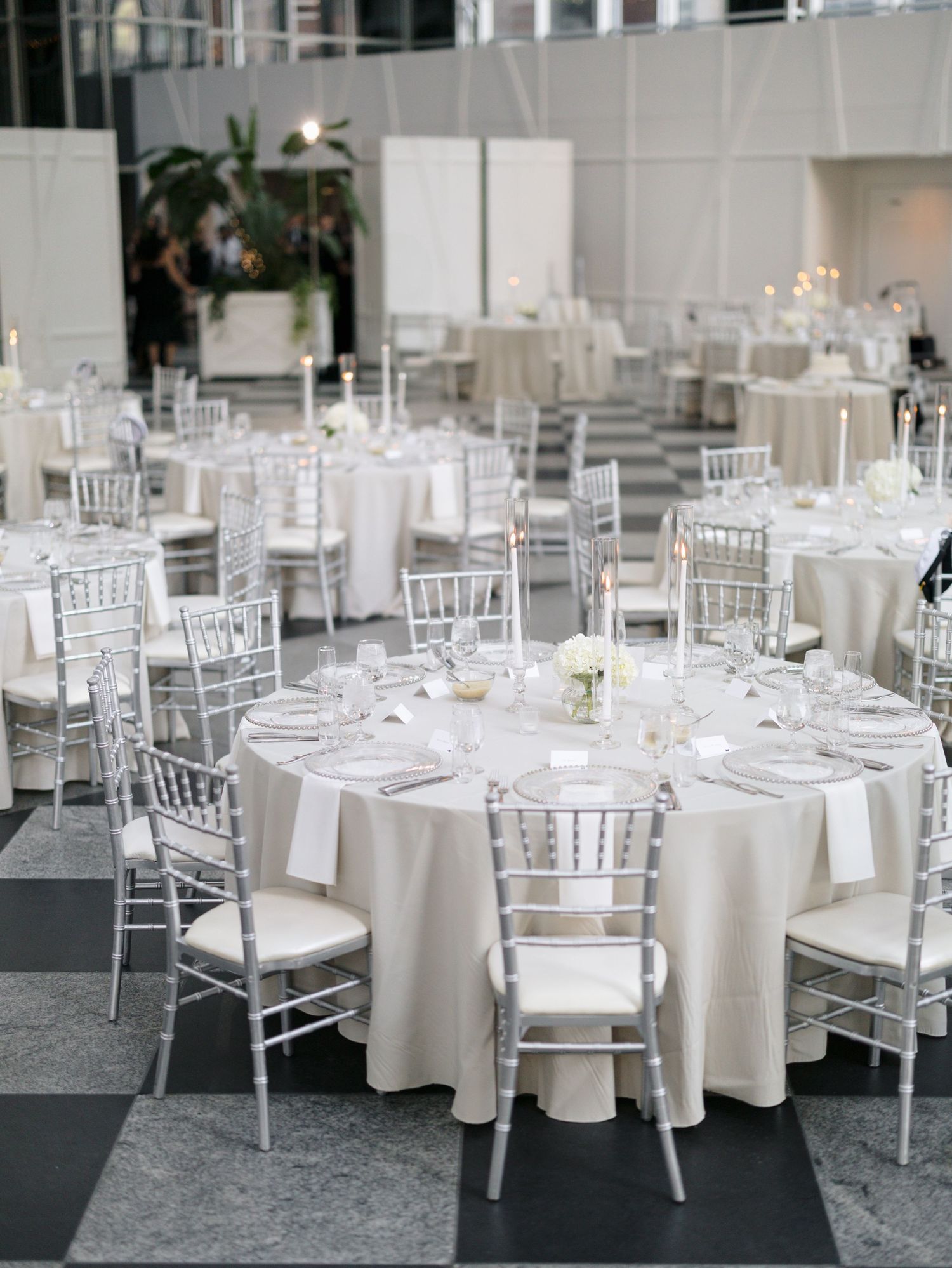 White and silver wedding reception setup with round tables, chiavari chairs and crisp linens.